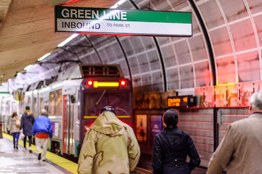 People walking towards Green Line train inside North Station