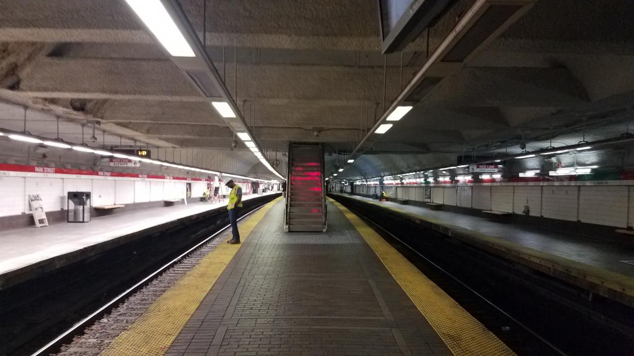 A worker stands on a platform at Park Street, where new LED light fixtures were installed on the Alewife platform in October 2019. Full lighting replacement is expected to be completed by December 2019.