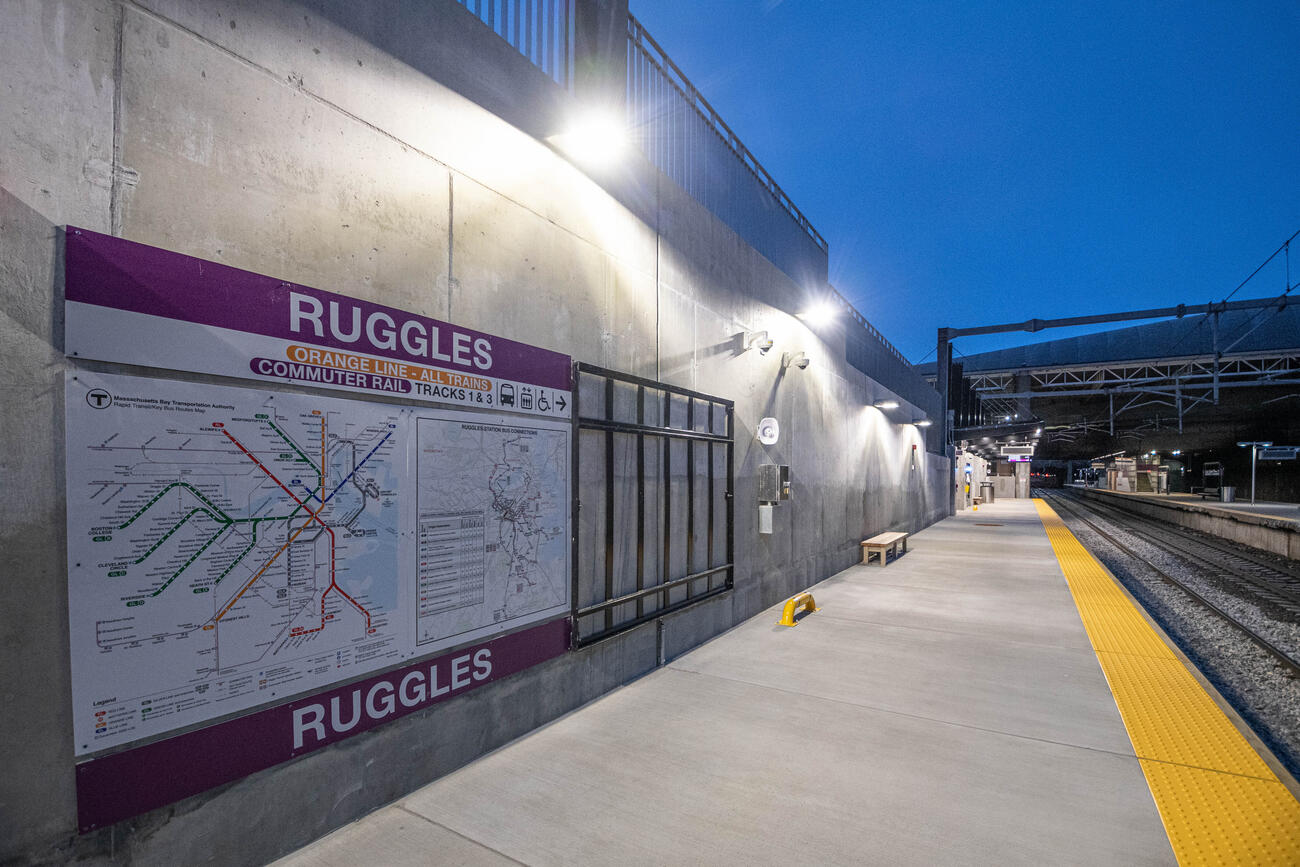 MBTA system map with Ruggles Commuter Rail platform at night in background