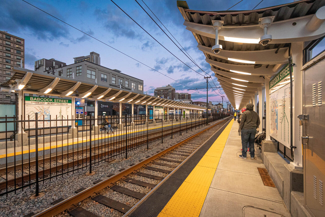 riders wait on the Babcock Street platform at dusk. the station opened on November 15, 2021
