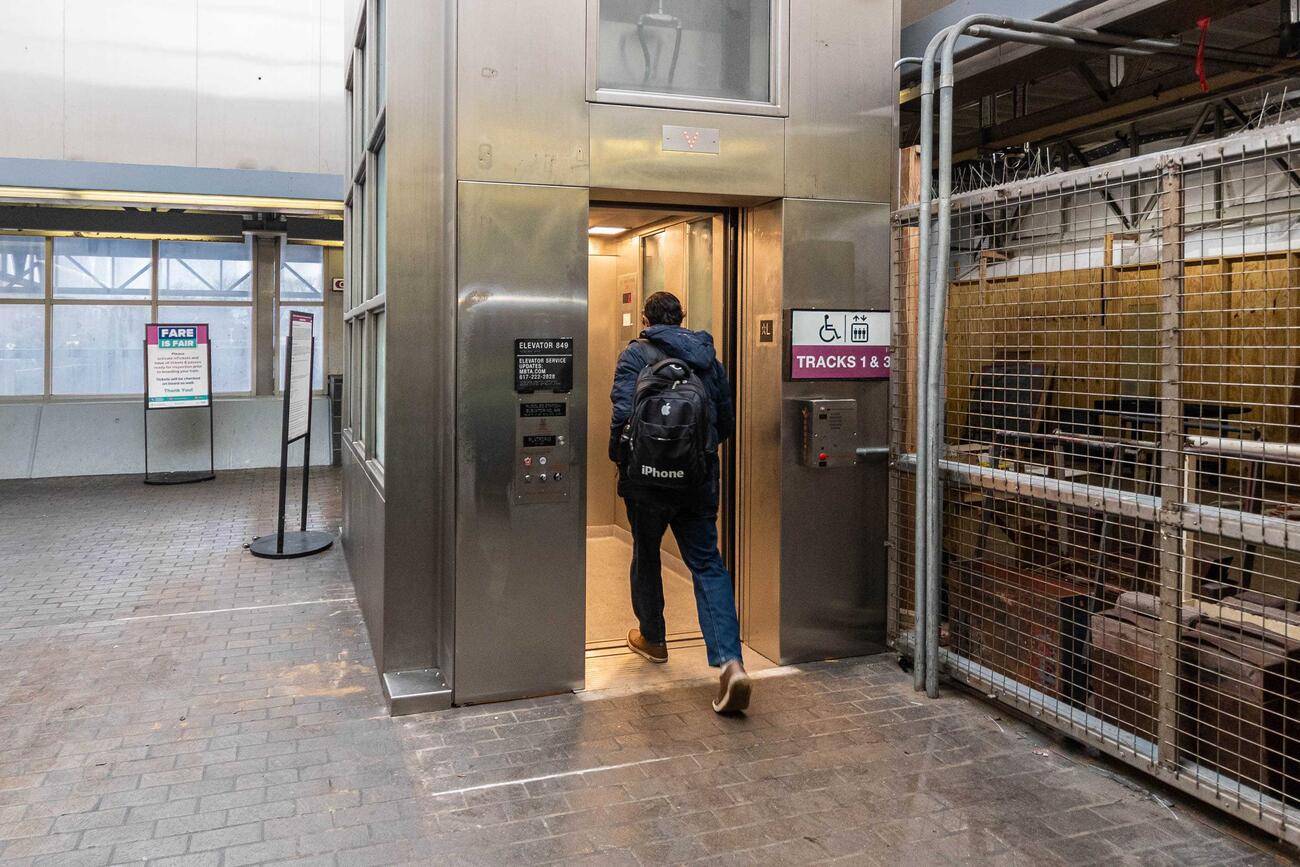 A passenger enters elevator 849 from the lobby at Ruggles station. This elevator takes riders down to Commuter Rail tracks 1 and 3.