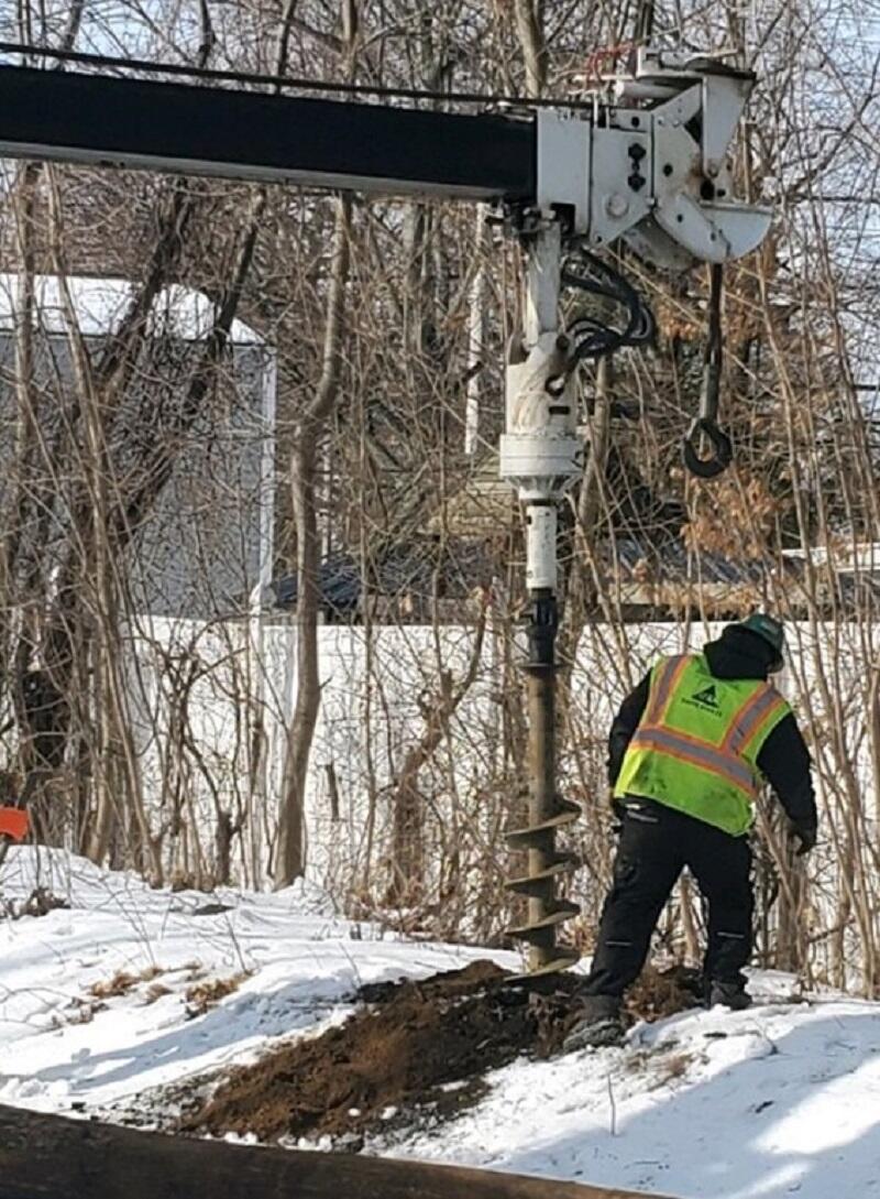 Image of crews performing auger-drilling operation for installation of ATC power poles on Newburyport Line