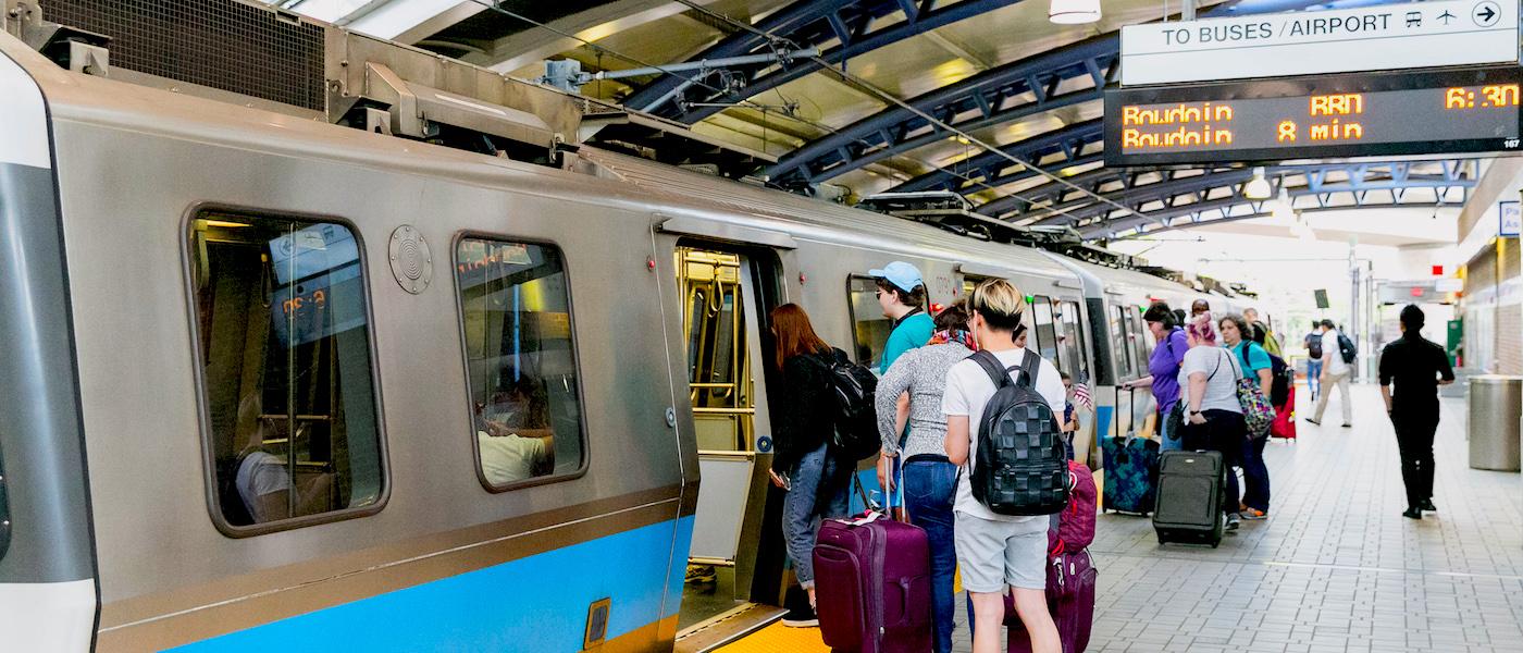 Riders exit and board a Blue Line train at Airport Station