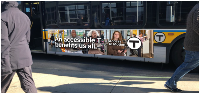 A series of five photos runs along the side of an MBTA bus: an African American woman using a guide dog; an African American man using a white support cane; an African American woman with white hair using a power wheelchair; a white woman with a non-apparent disability holding a tablet; and a white man with a non-apparent disability pushing an assistance button on a train. The words “An accessible T benefits us all.” followed by the “Access In Motion” tagline and the T logo appear in the foreground.