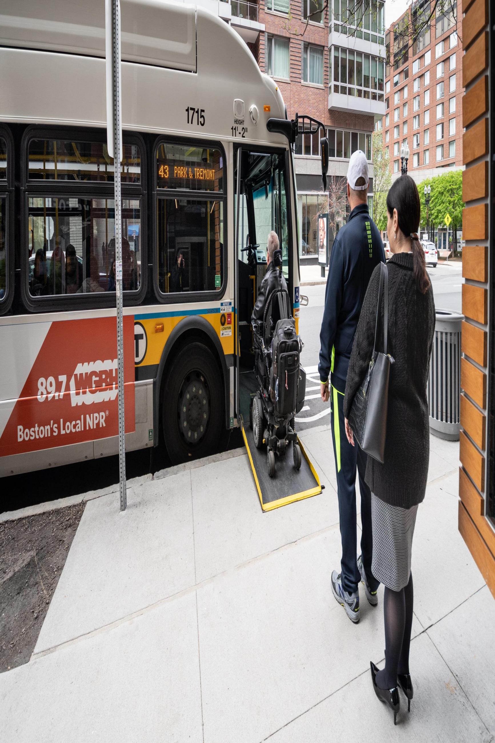 wheeled mobility device user boarding with ramp