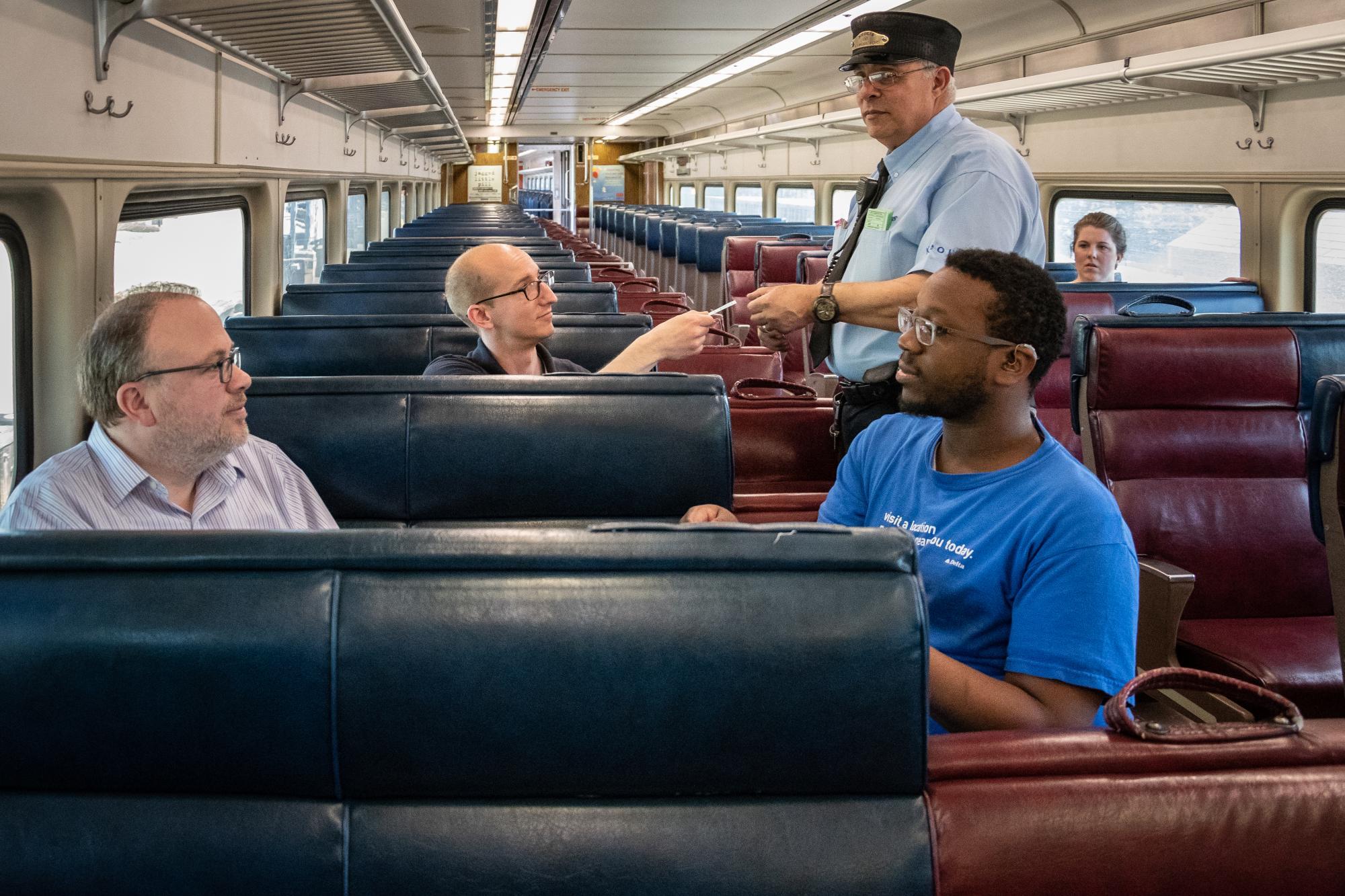 conductor validating commuter rail fare