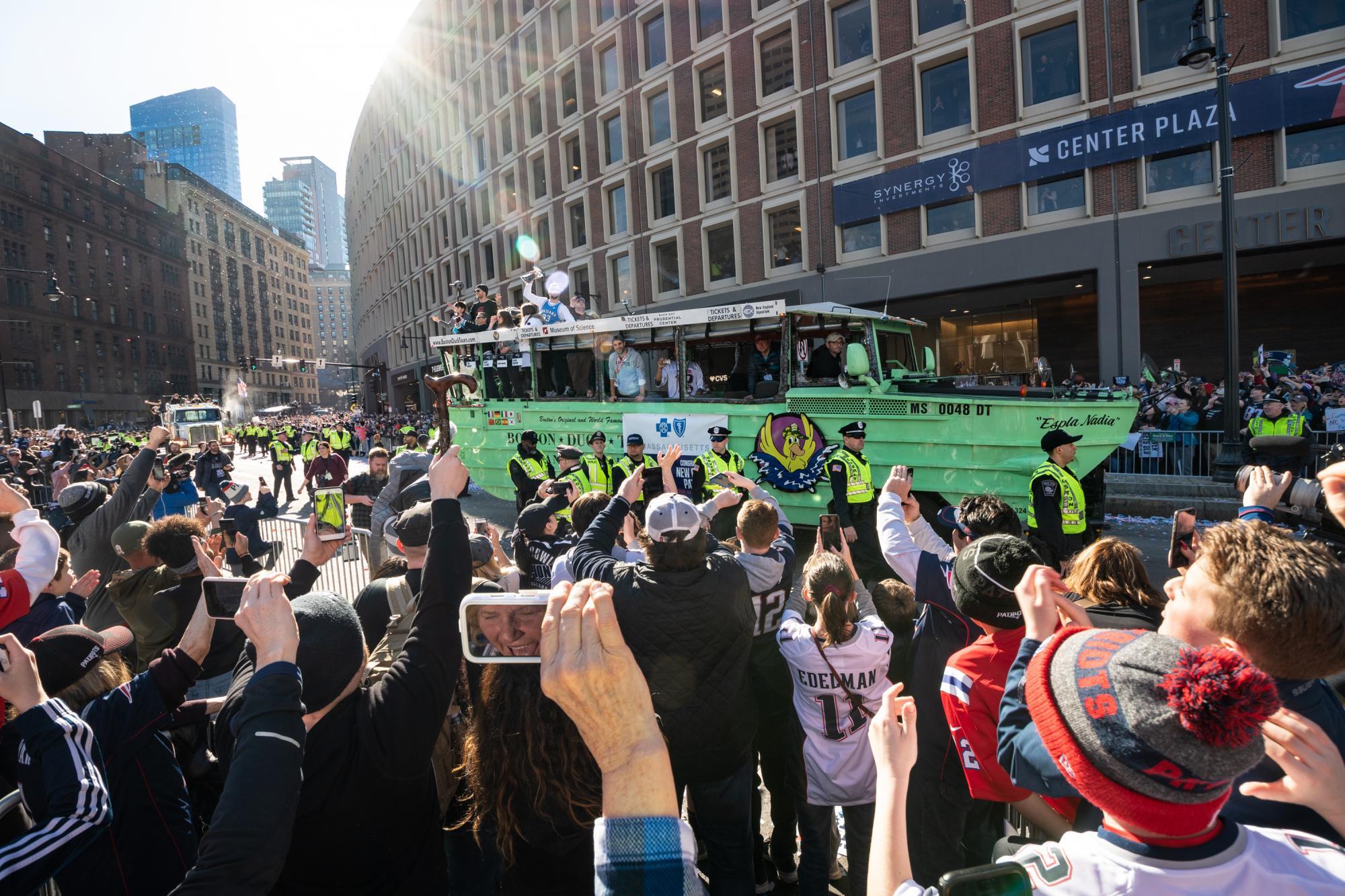 Crowds at Government Center cheer on the Duck Boats with Patriots players.
