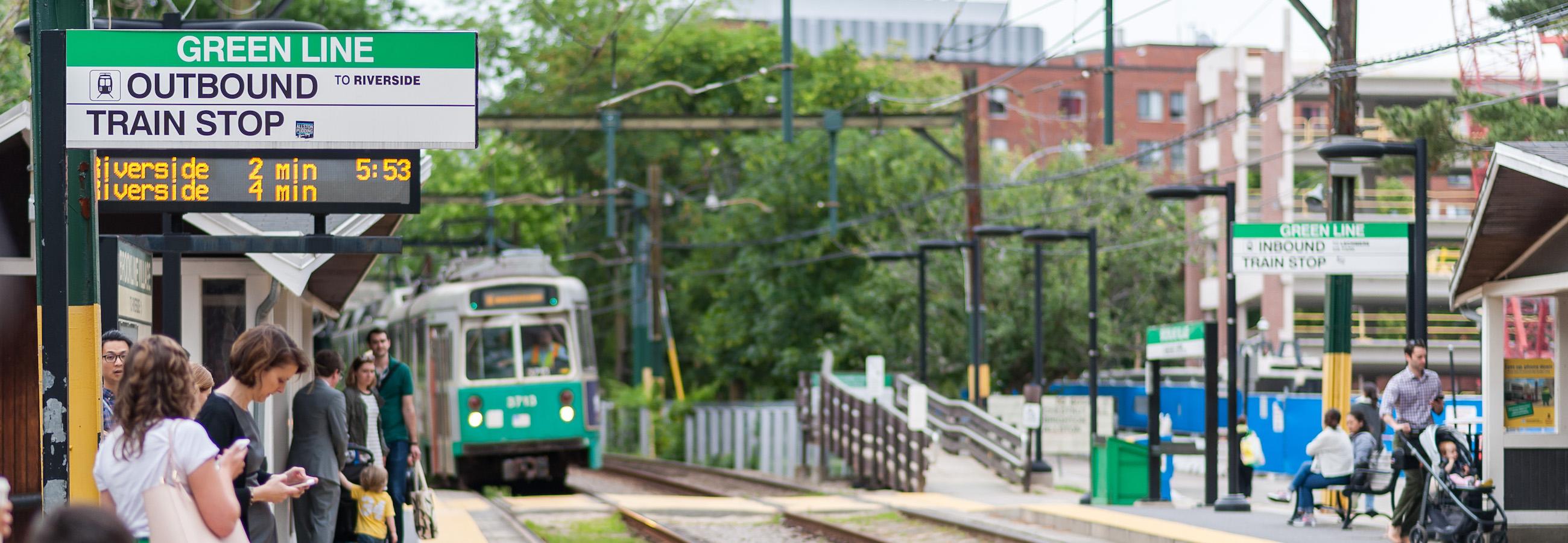 customers wait for arriving green line train at brookline village