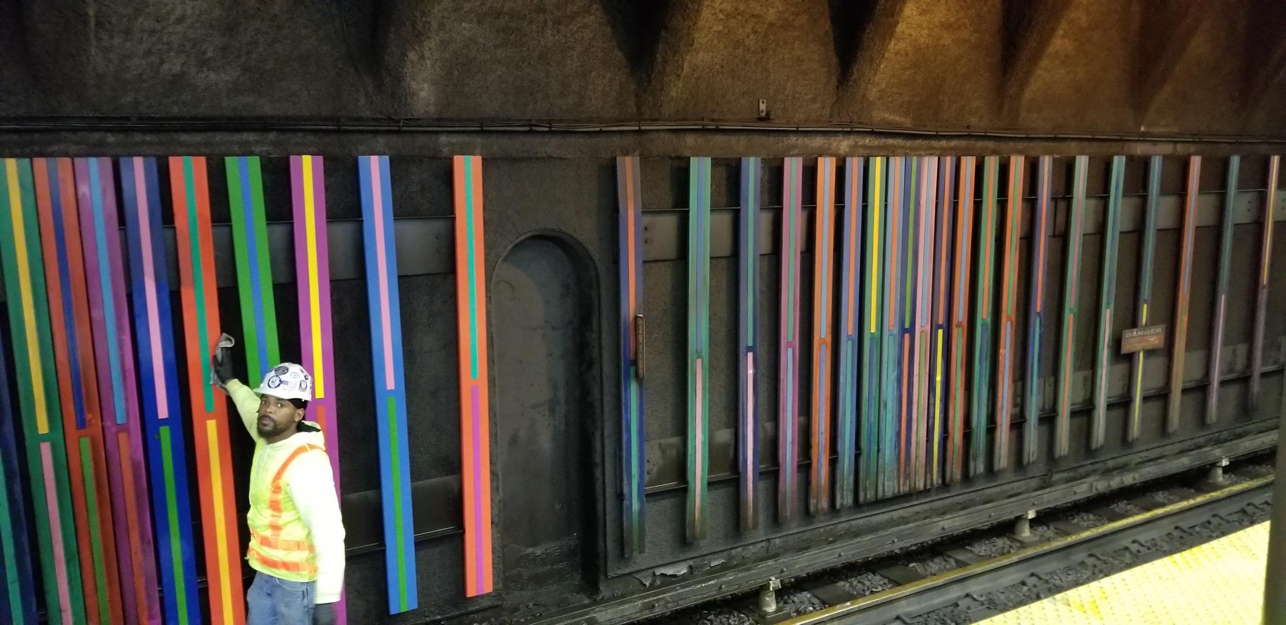 A worker cleans Toshihiro Katayama's “Colors on the Line” artwork on the tracks at Chinatown Station during the Oct. 4 – 6, 2019, Orange Line weekend service shutdown.