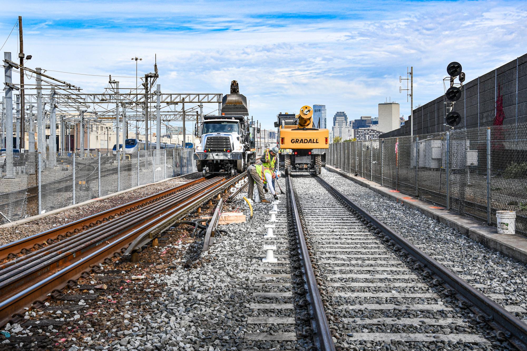 Crew members prepare to install third rail alongside the new Red Line track at Cabot Yard