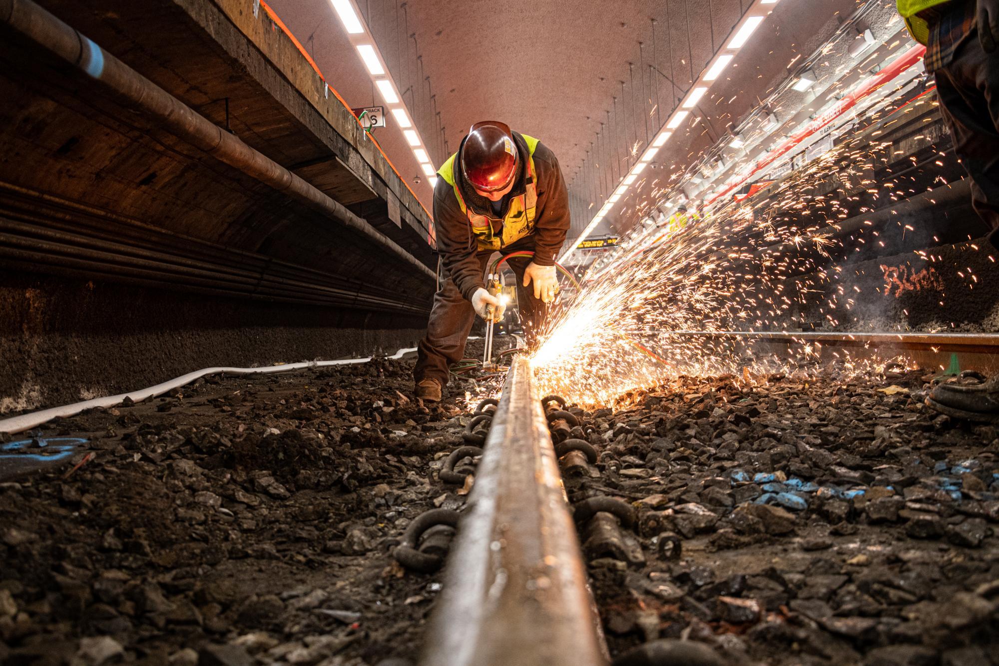 A crew member welds a section of track at Park Street as part of the December 6 – 8, 2019, Red Line weekend shutdown