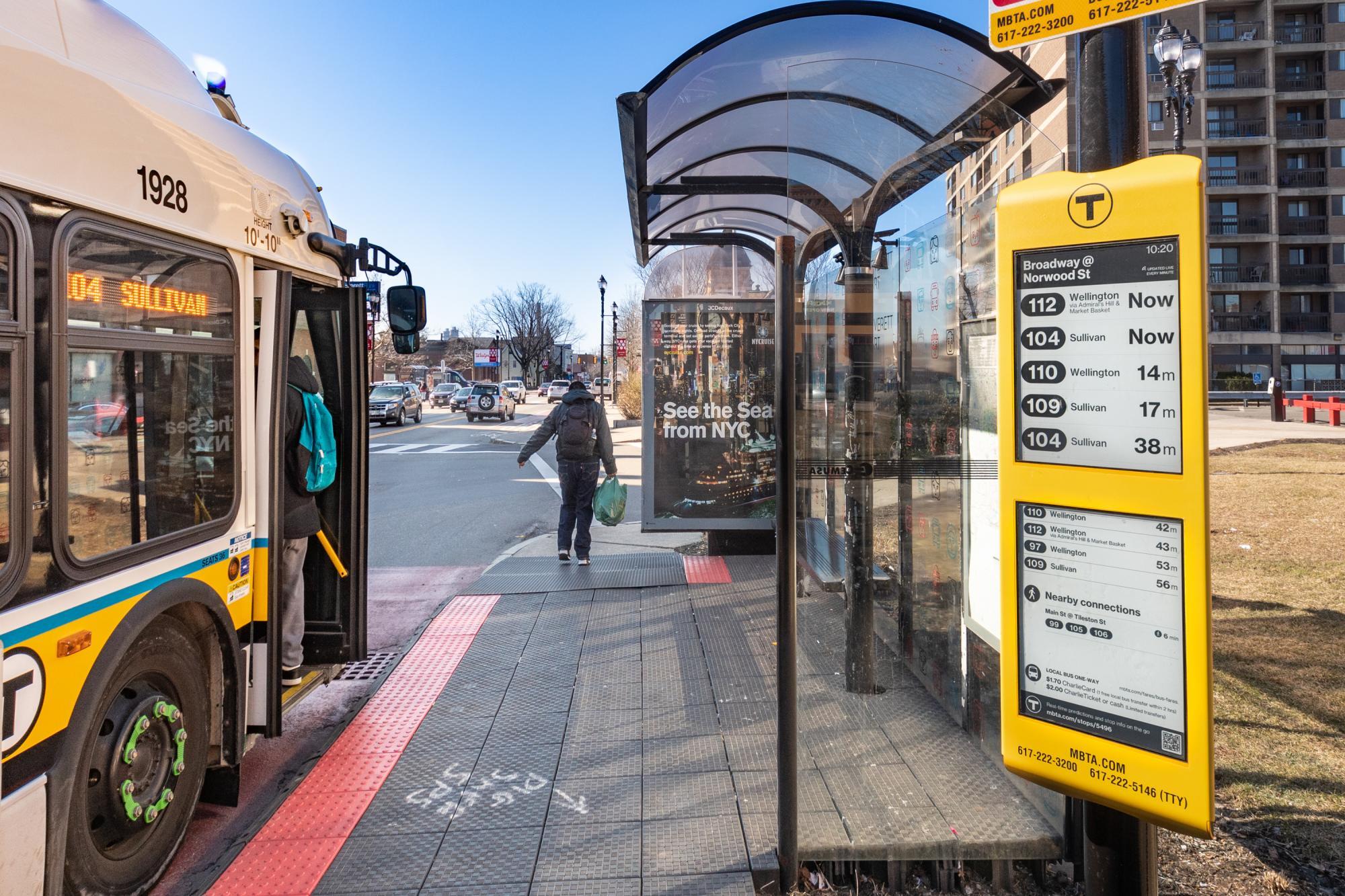 A rider boards a bus near the new E Ink sign at the Broadway bus stop in Everett