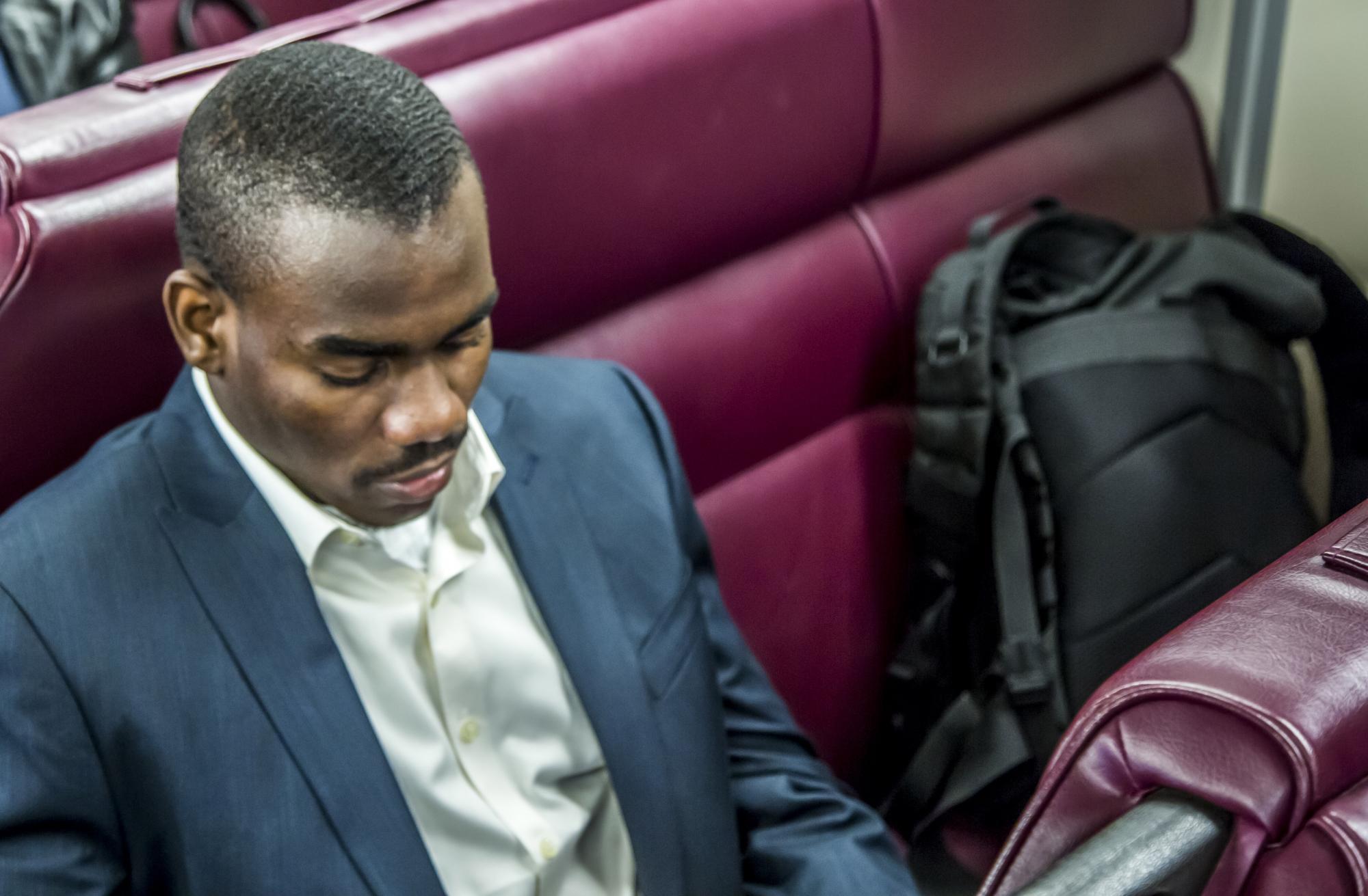 A rider in a suit on a Commuter Rail train on the Fairmount Line