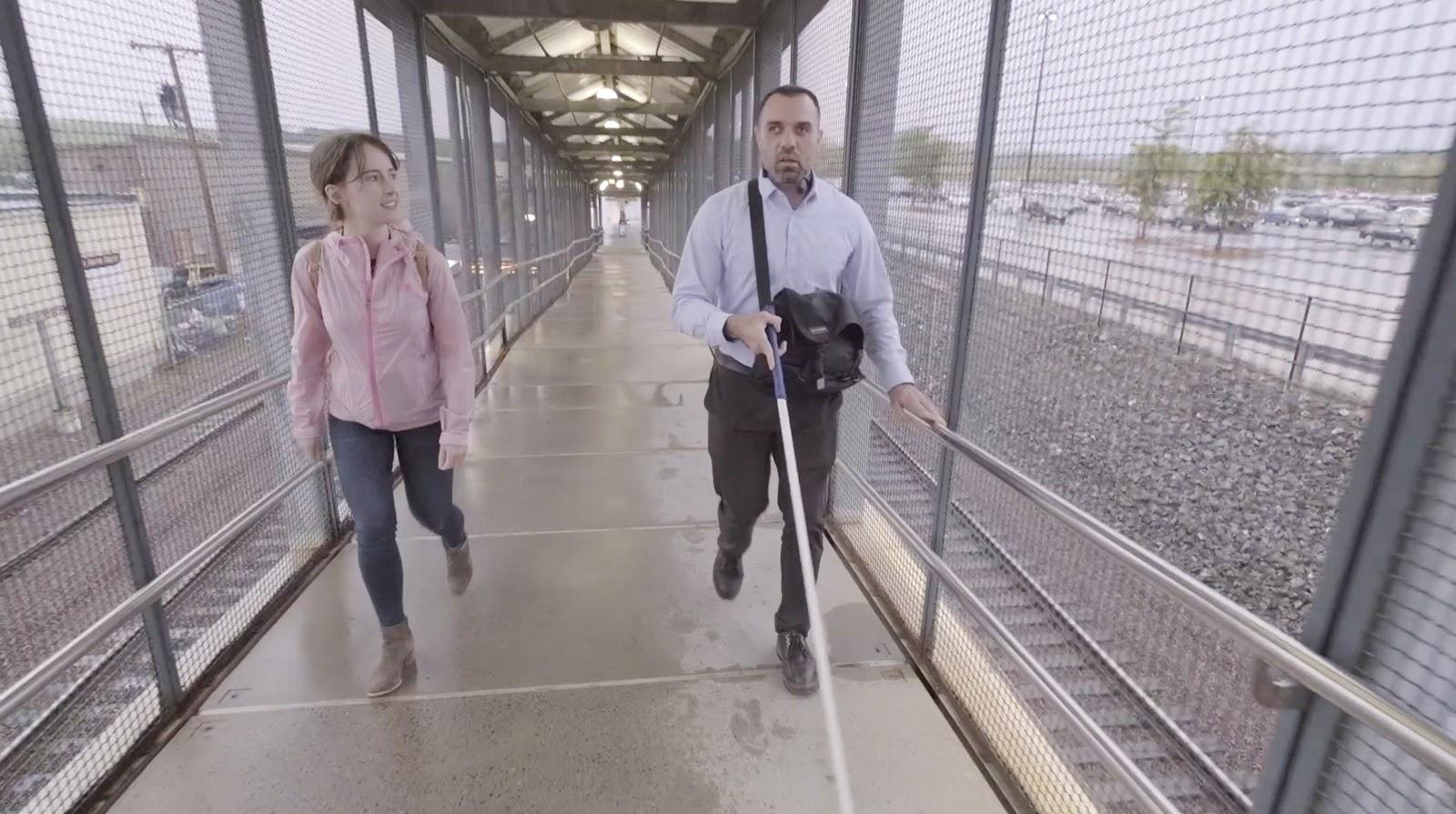 A CTD employee walks with a rider during a user research study for blind and low vision riders