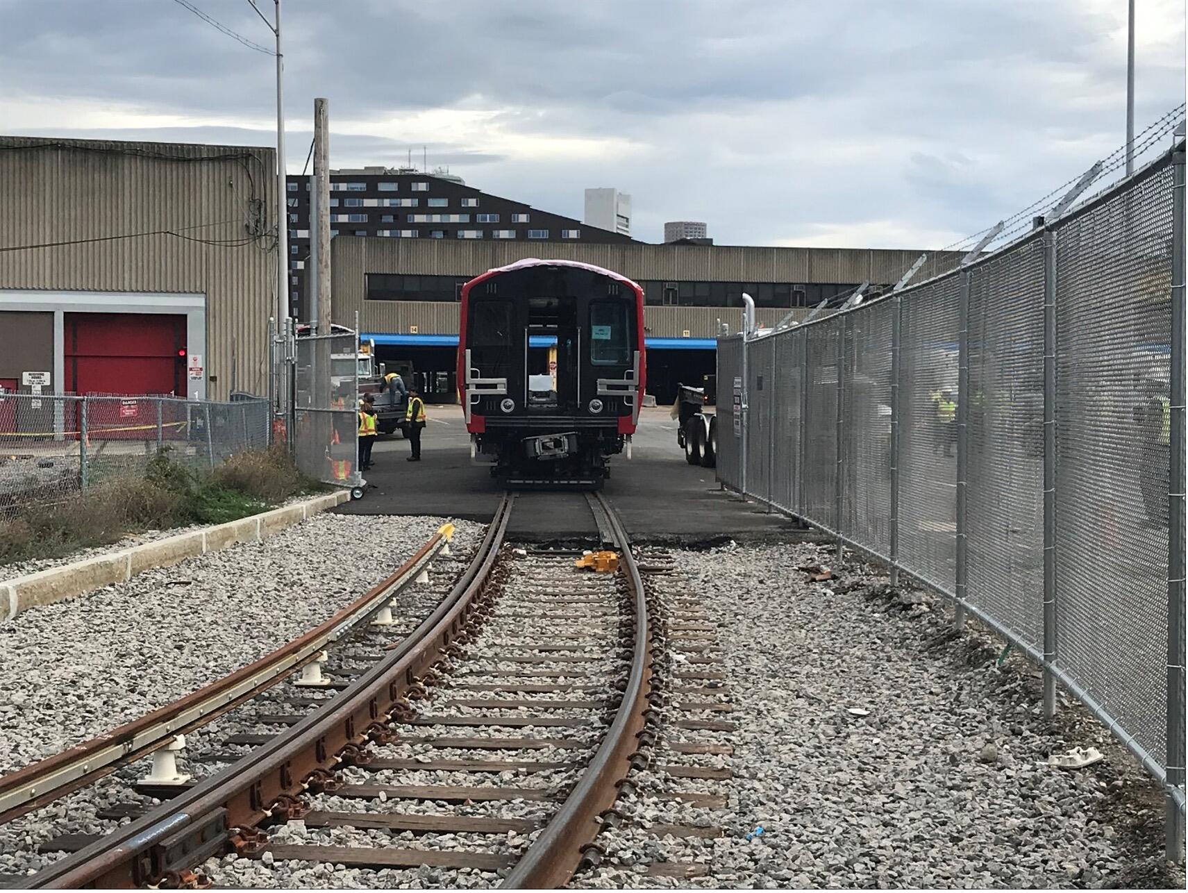 A new Red Line train vehicle on a loading track, shown from the tracks behind