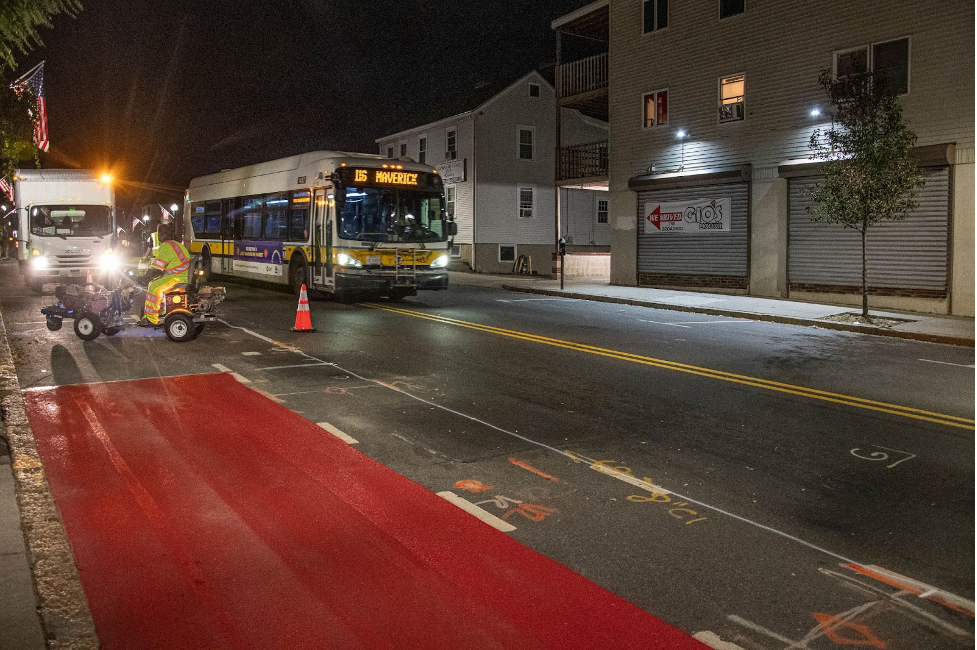 A route 116 bus passes construction crews installing the new bus lane markings on Broadway near Cushman Ave in Revere on October 20, 2021