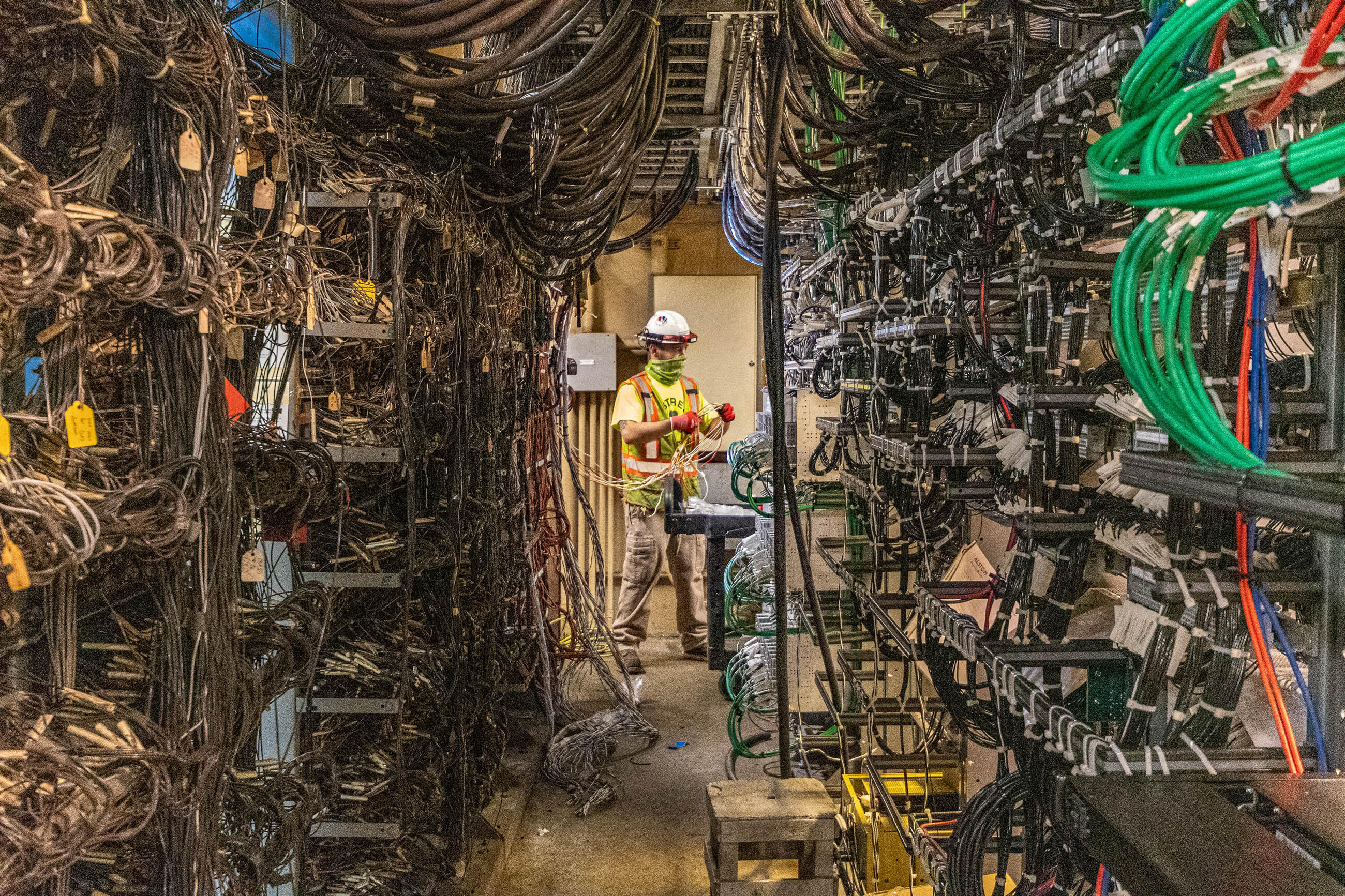 A worker continues to connect and wire the new signal equipment