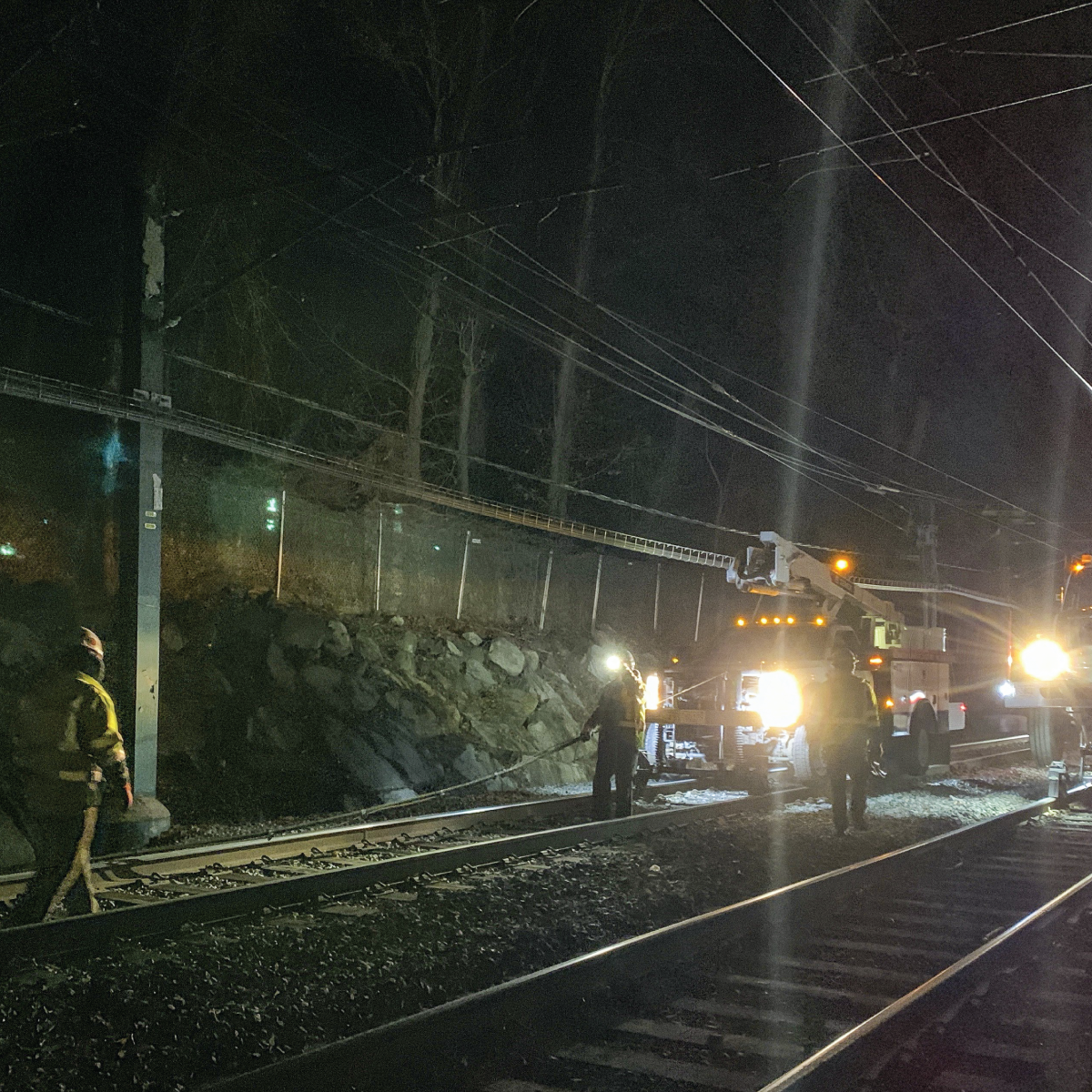 Crews working under floodlights at night to replace signal cable along the D Branch 