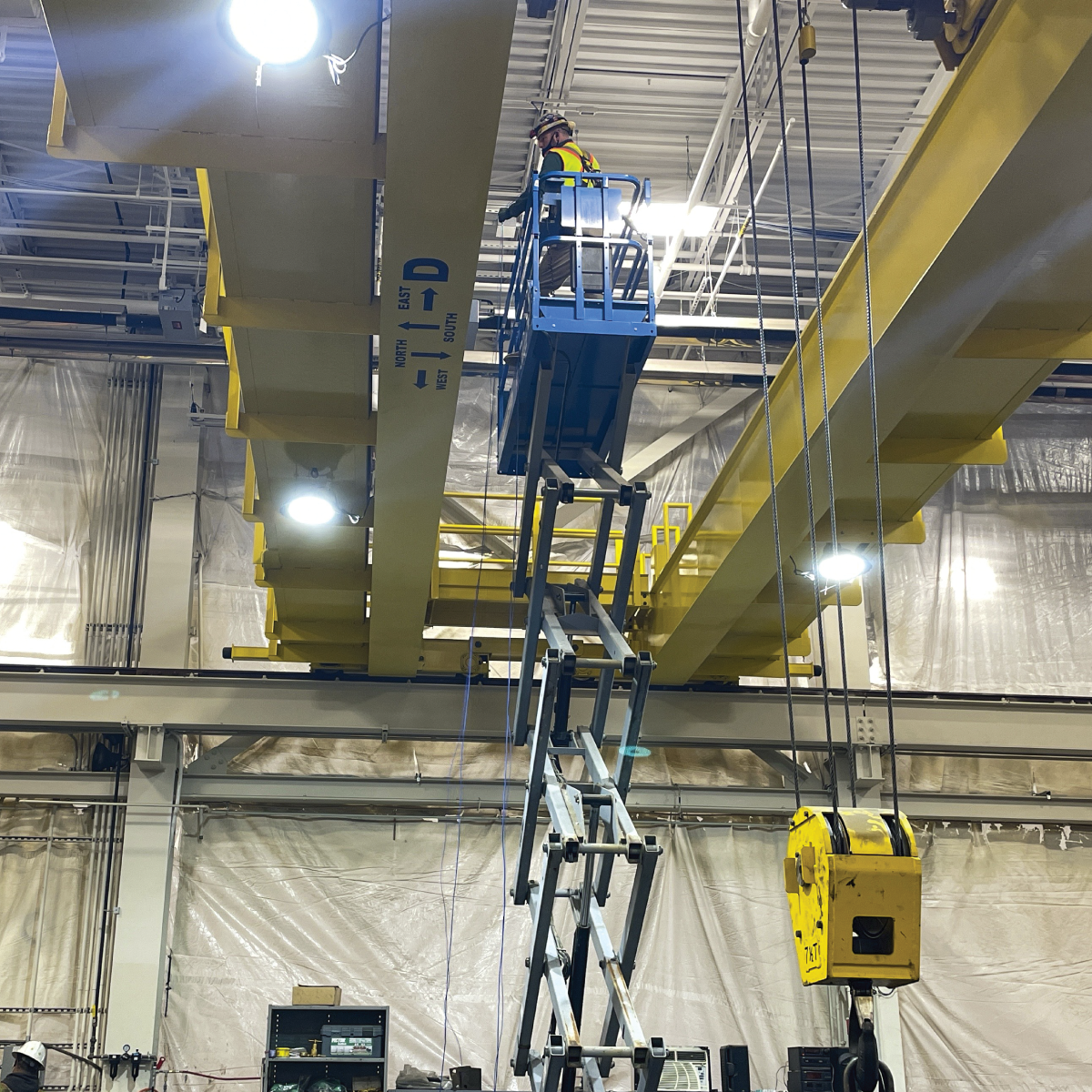 A crew member in a lift working on crane machinery at the Wellington Vehicle Facility