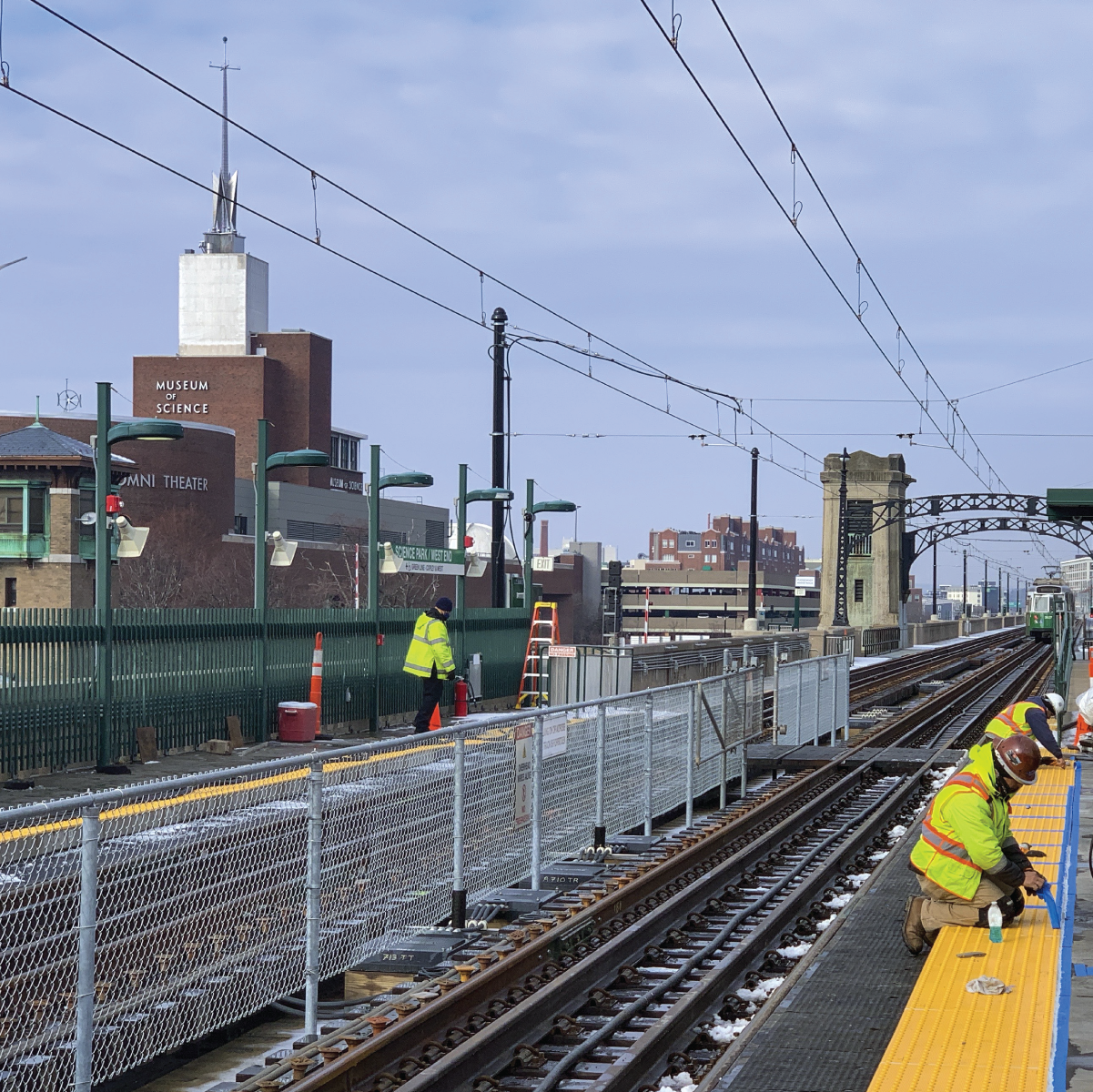 Crew members replacing tactile strips by green line tracks at Science Park