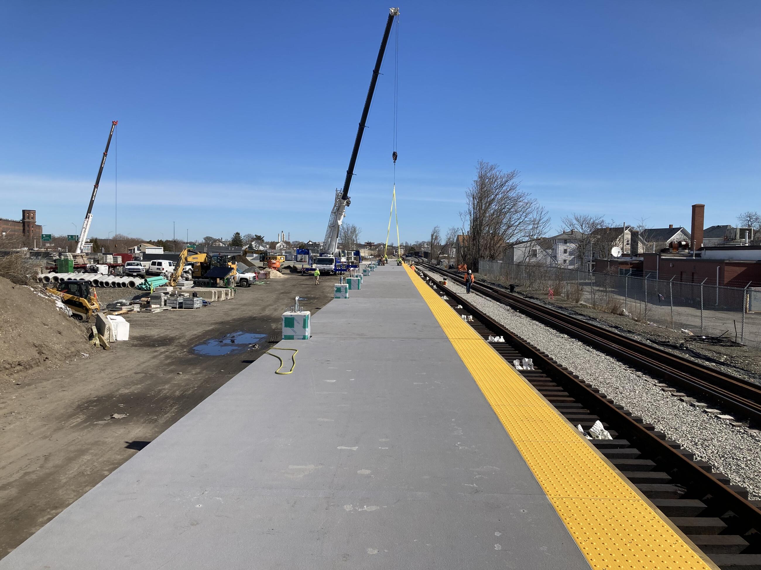Workers use a crane to put rail platforms into place at the Fall River Depot Station