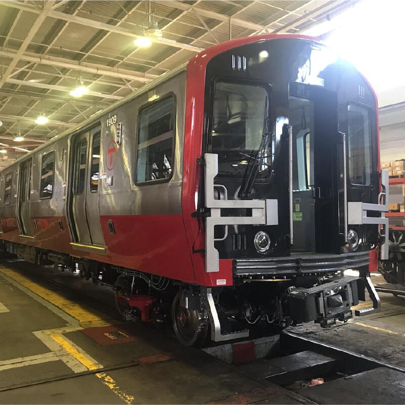 A shiny new red line train vehicle inside a building
