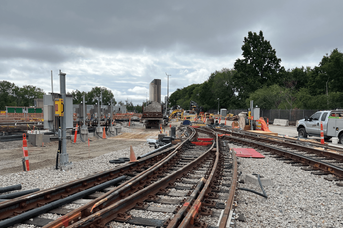 tracks in wellington yard on an overcast day. there's a dump truck full of ballast next to the tracks