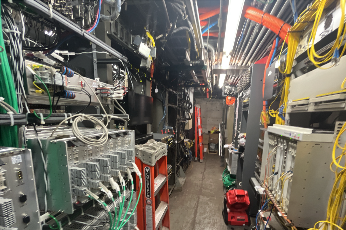 a narrow path between walls of signal equipment (wires, switches, many electrical cords)