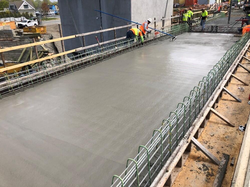 Workers smoothing concrete deck