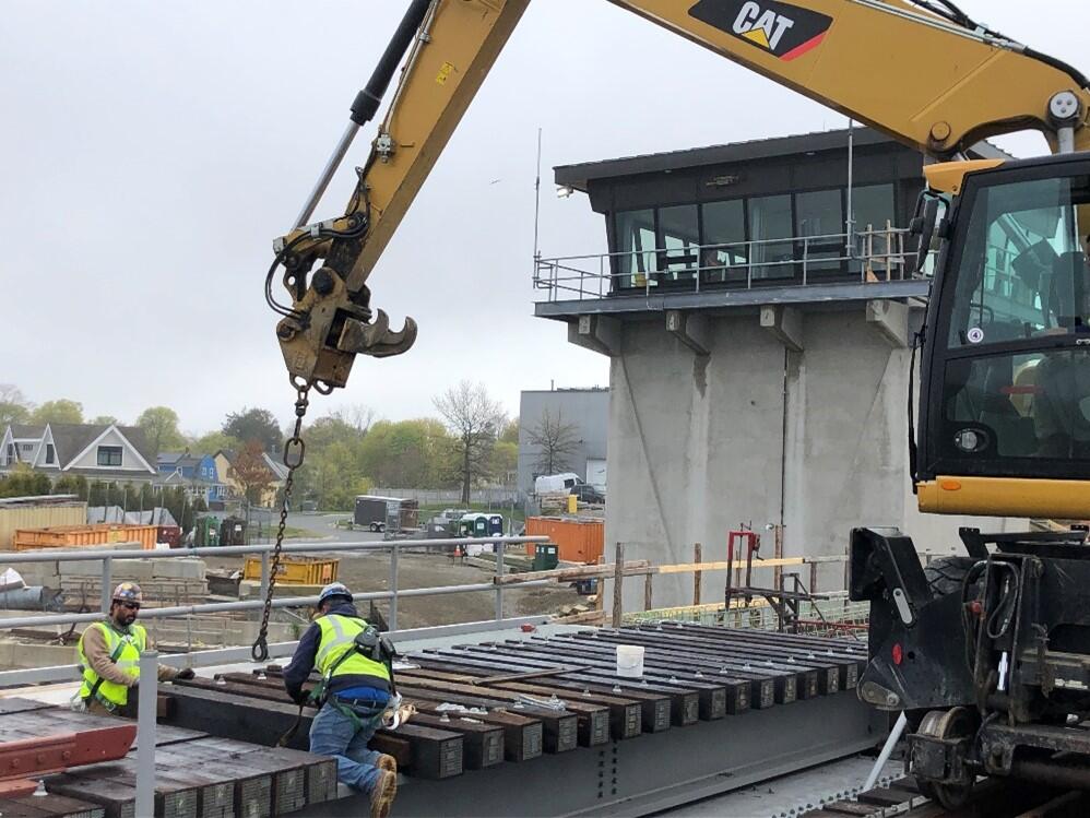 Construction equipment installing bridge railing