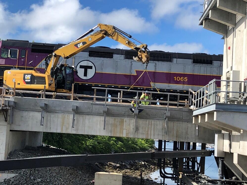 Construction equipment installing bridge railing