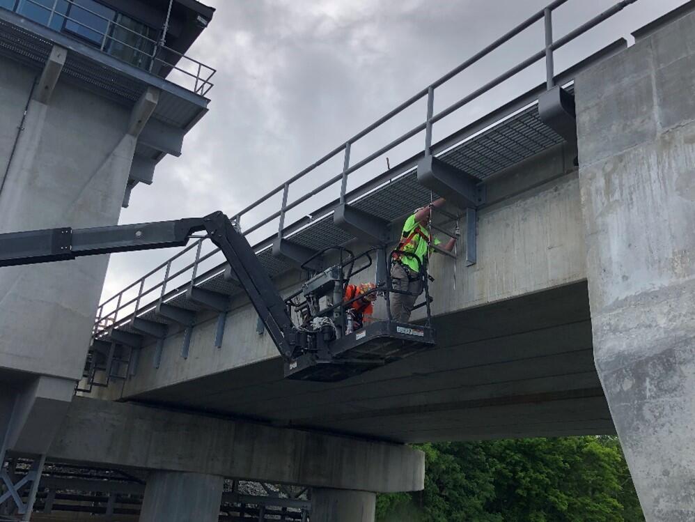 Construction workers install support brackets