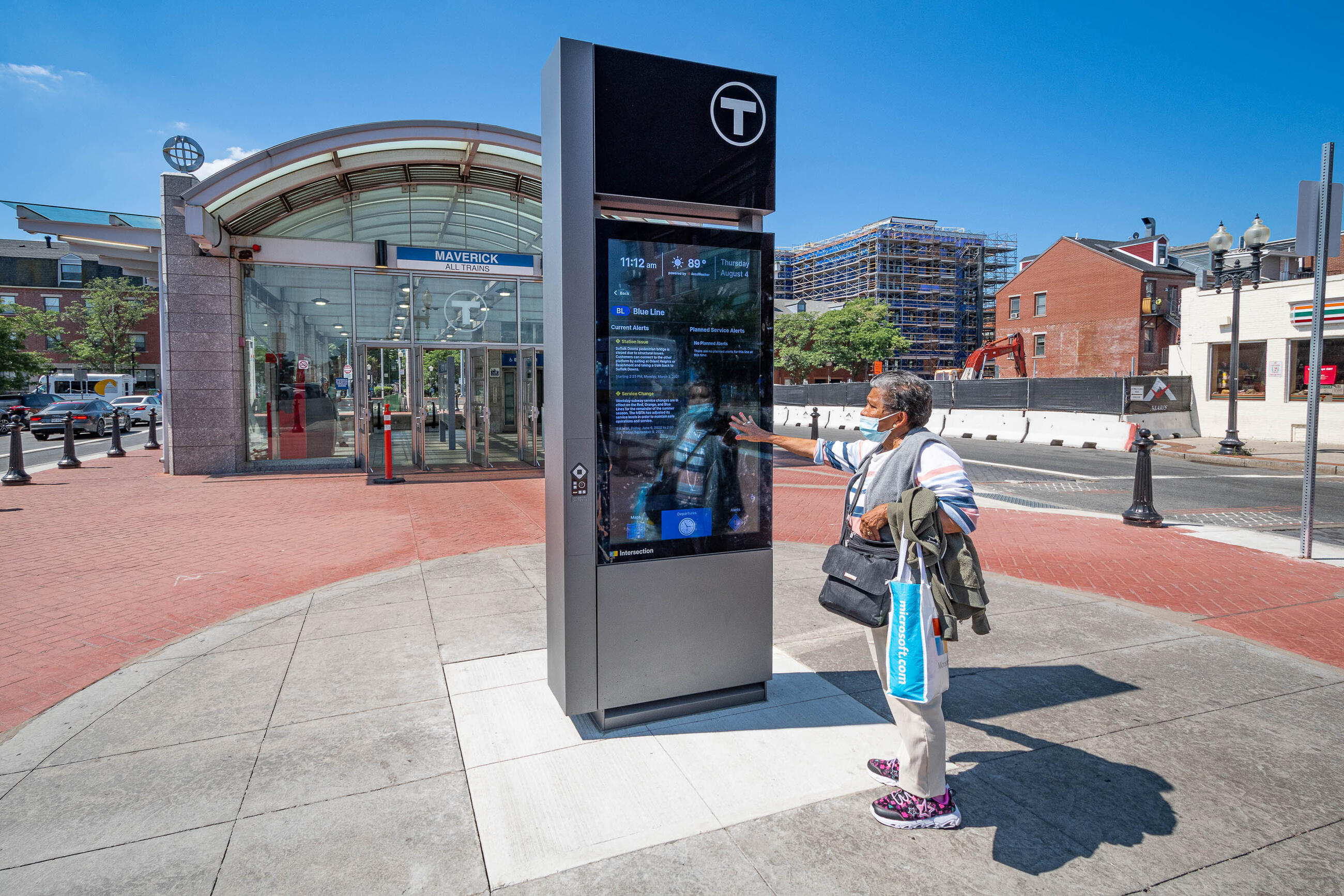 A rider looks at a digital kiosk sign at Maverick station