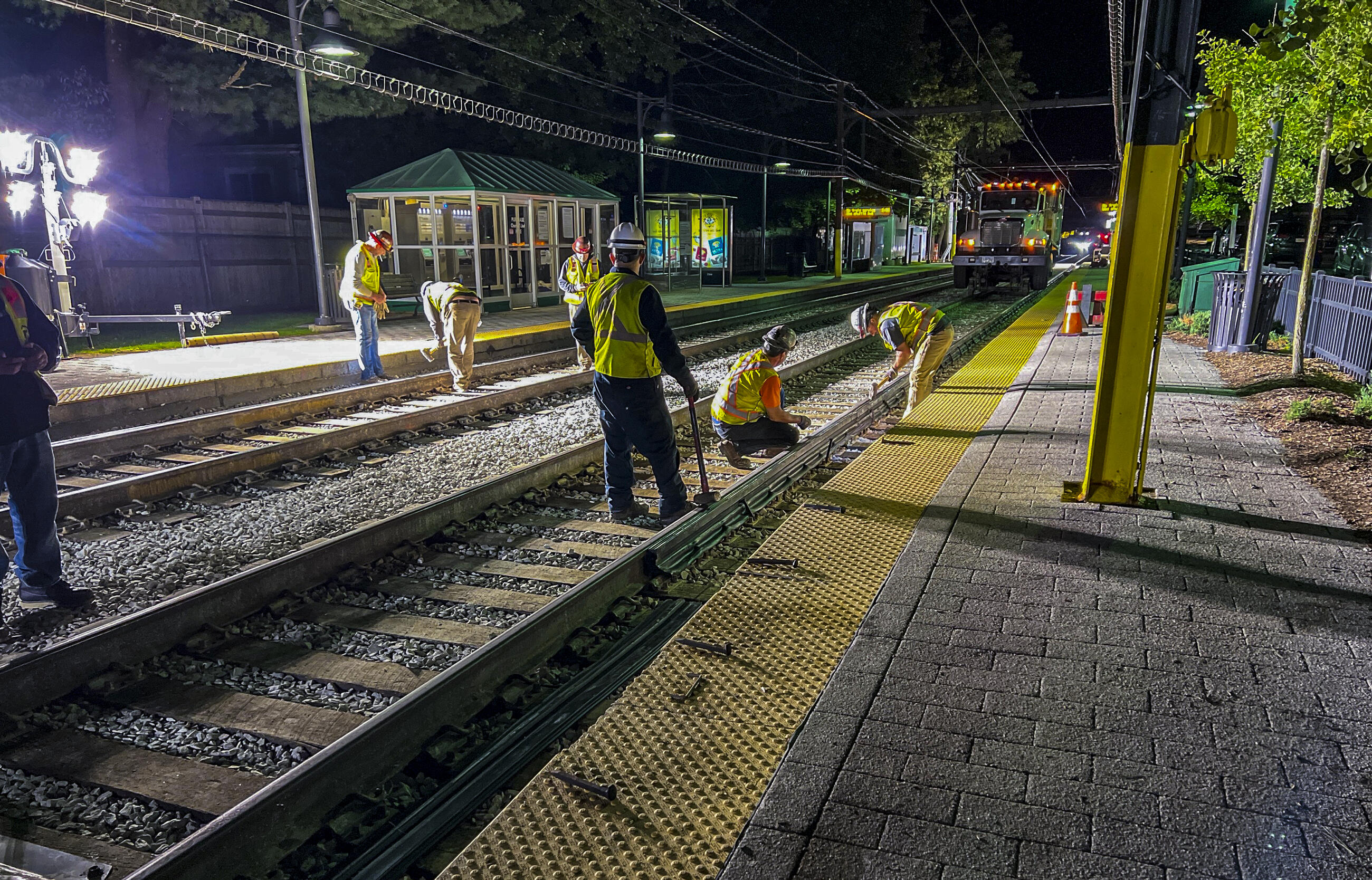 crews working on the d branch under floodlights at night