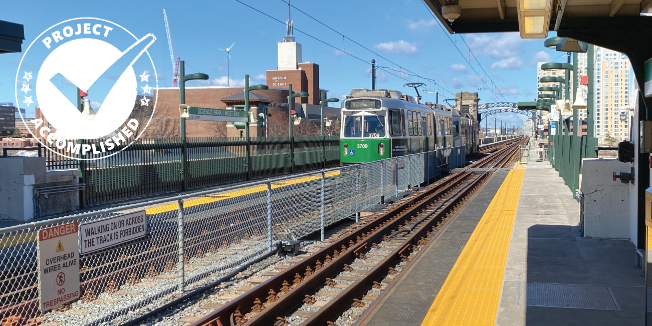 a green line train at science park station on a blue sky day