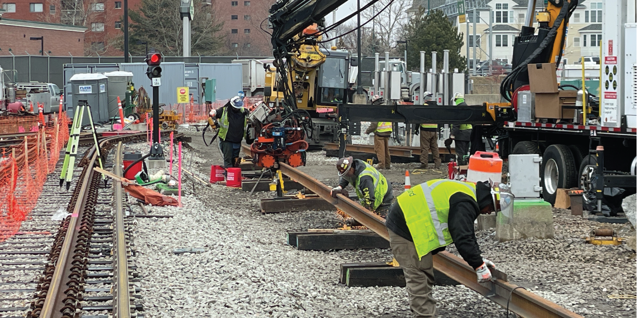 crews working on a stretch of track rail outdoors
