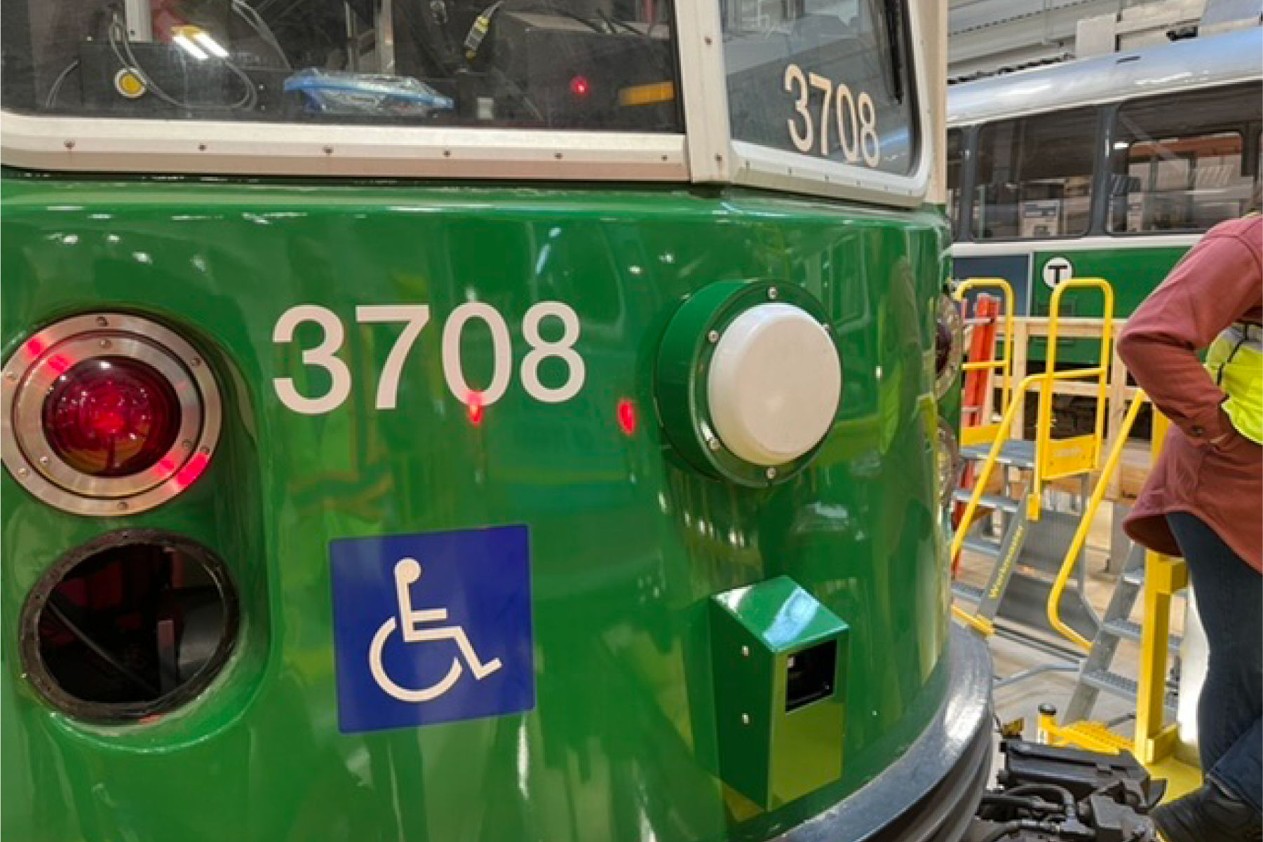 a close-up photo of the front of a green line test car with round radio antenna and radio sensor box installed 