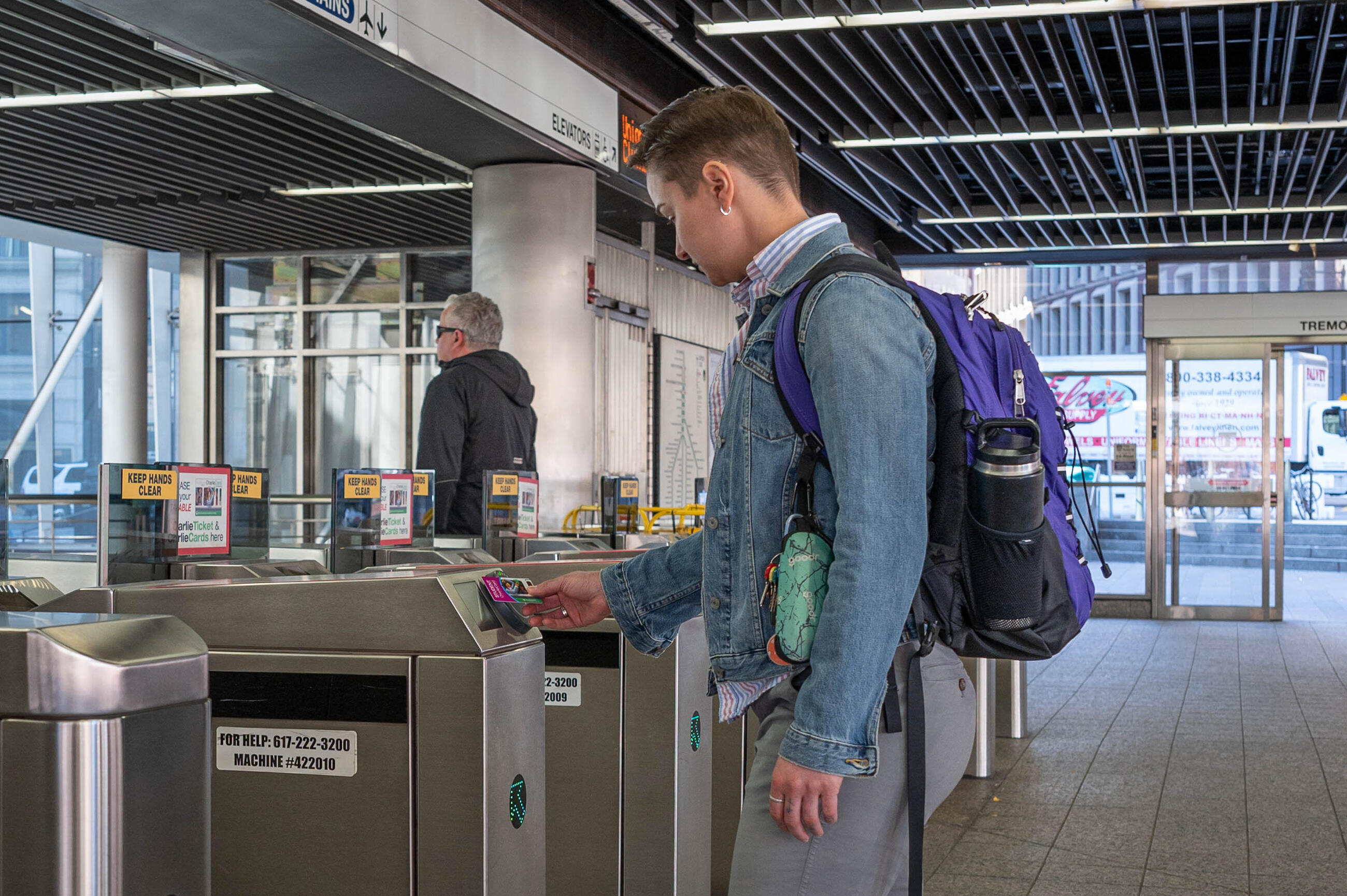 Rider entering fare gate wih student CharlieCard