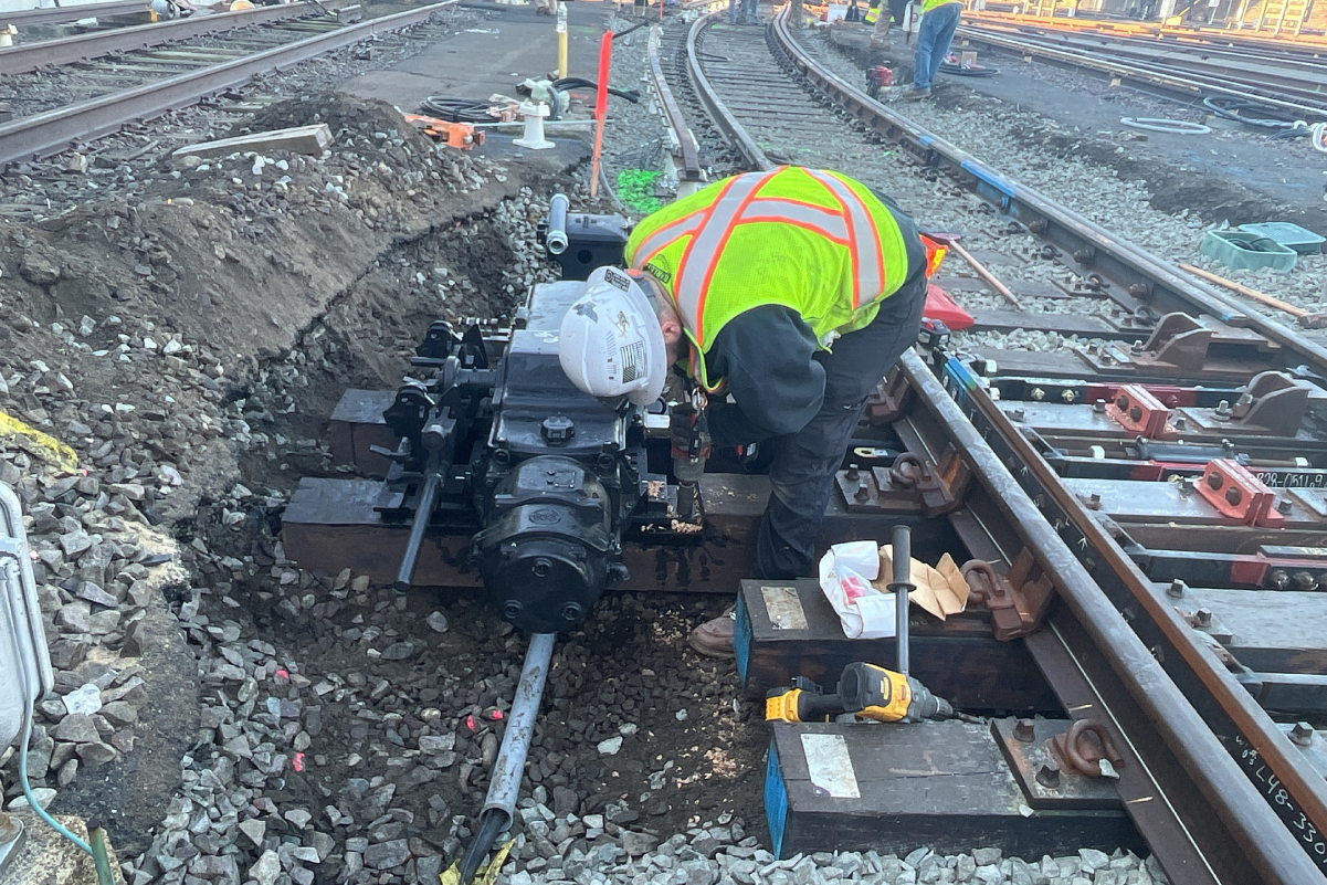 Workers installing switch on railroad tracks
