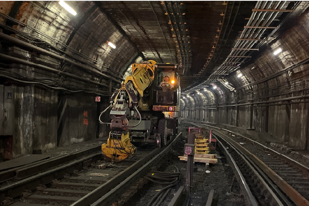 crew member using construction equipment in underground tunnel