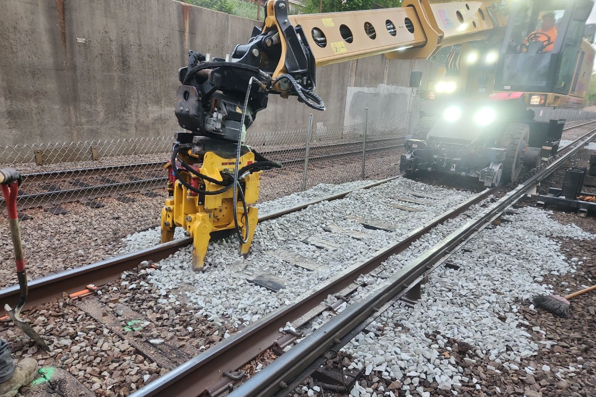 construction equipment with a claw-like attachment over some rail tracks