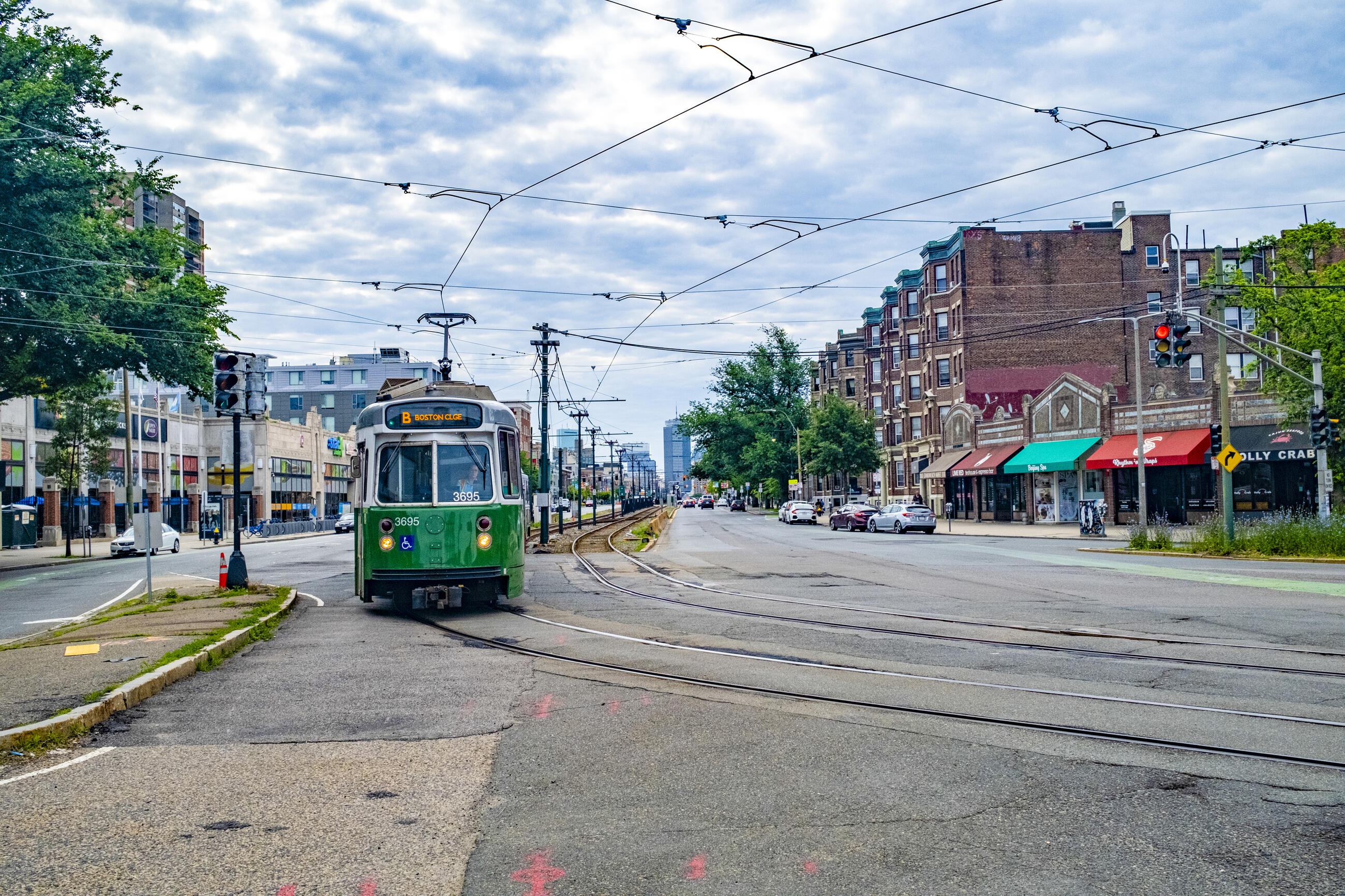 A Green Line B Branch train rides on tracks at street level. The full-depth track replacement will take place at Blandford Street, Packard’s Corner, and from Harvard Avenue to Griggs Street Stations.