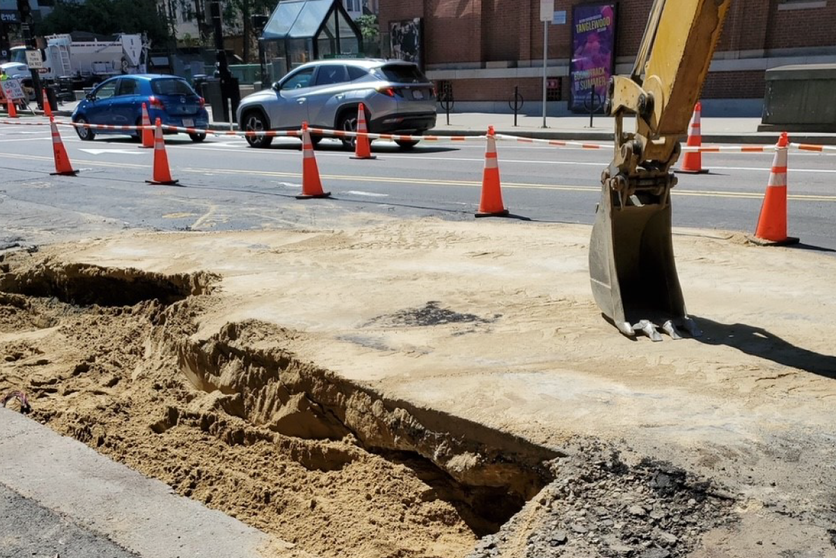 photo of hole partially filled with dirt in asphalt of road
