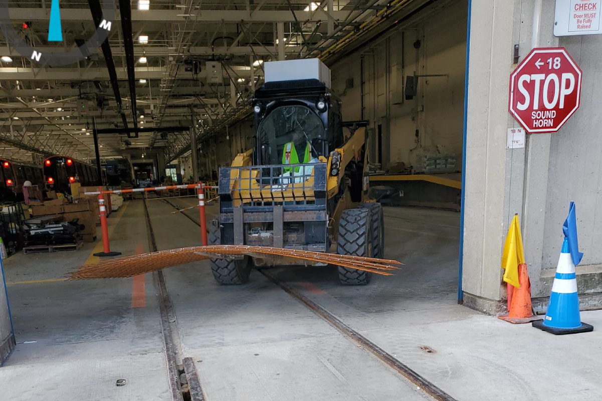 forklift carrying small pile of large metal mesh