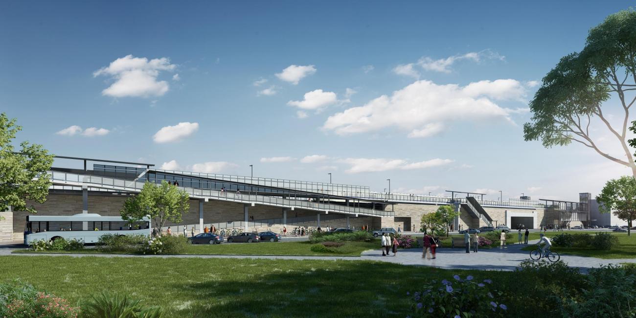 Rendering of a long tan building that will serve as a train station. Grass is in the foreground and blue skies behind.