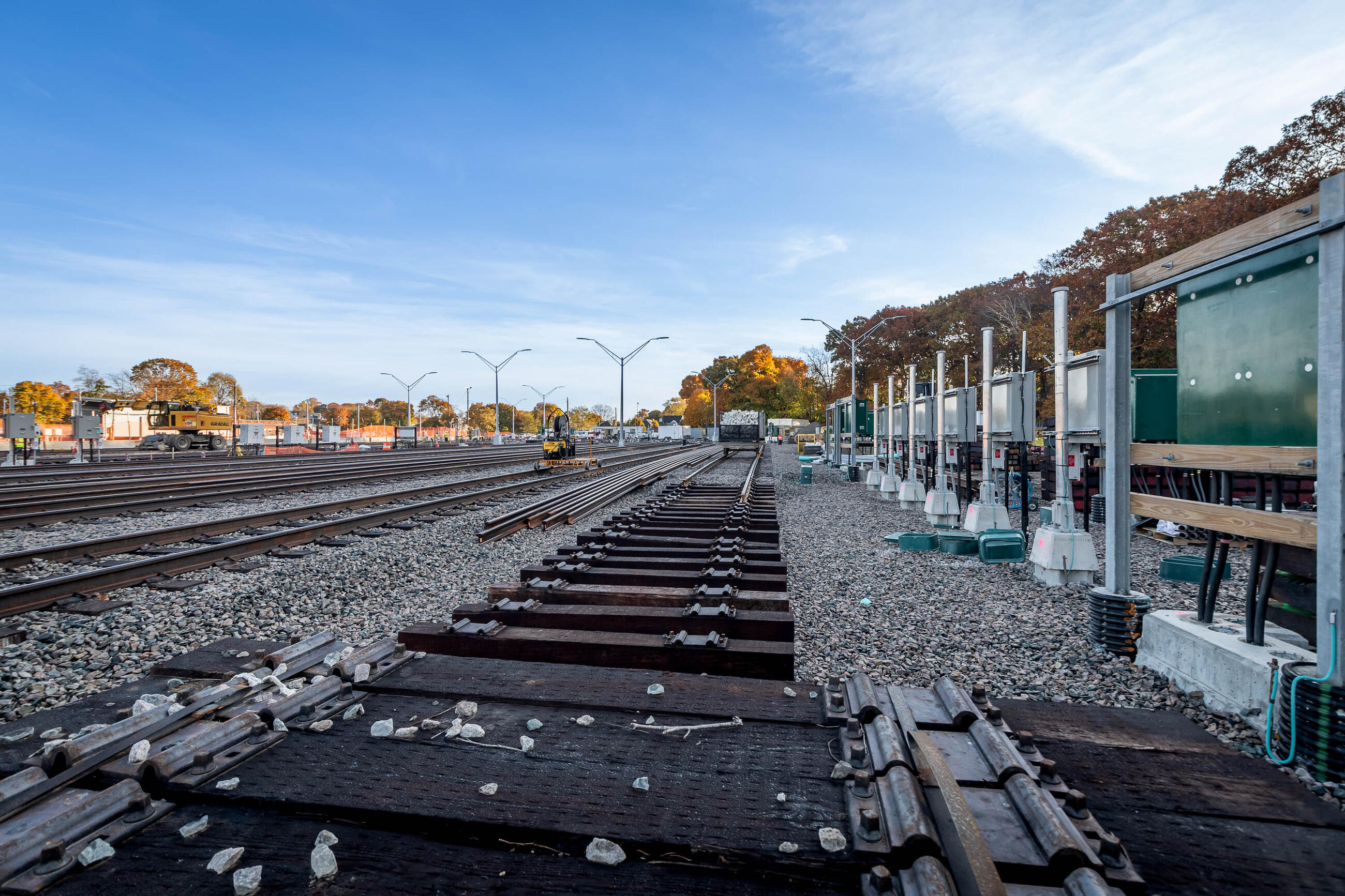 A view of the work zone with new lighting in the distance, tracks on ballast in the foreground