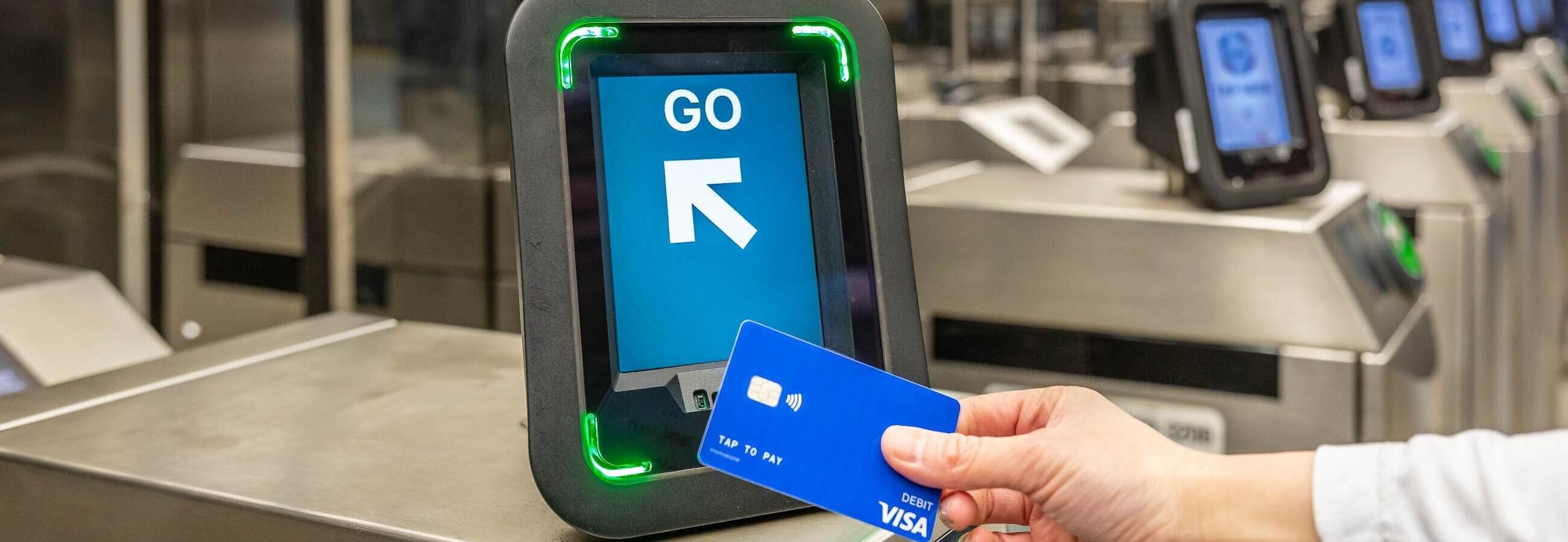 Rider tapping Visa card on Charlie reader at a subway fare gate