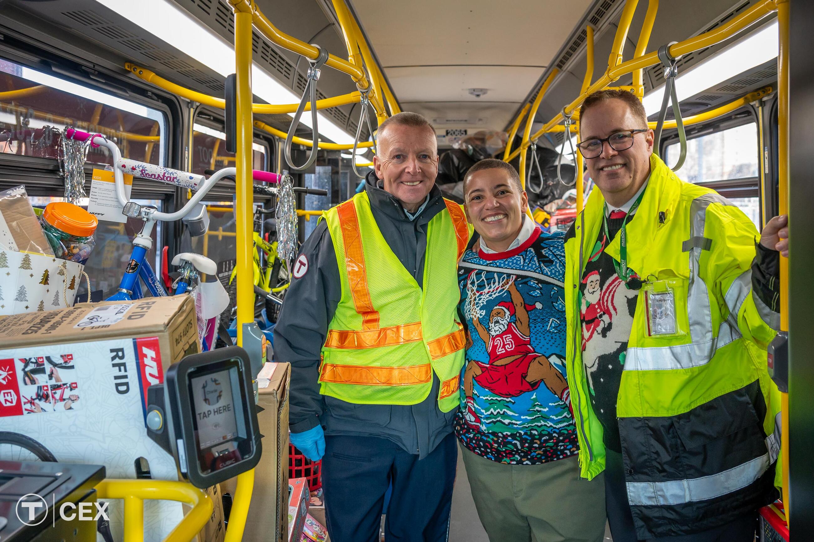  Left to Right: MBTA Bus Operator Broderick, who drives the holiday bus route each year; Transportation Secretary and CEO Tibbits-Nutt; and MBTA Graphics Manager Wood, who has organized the Fill-A-Bus with Gifts event for the last seven years. Complimentary photo by the MBTA Customer and Employee Experience Department.