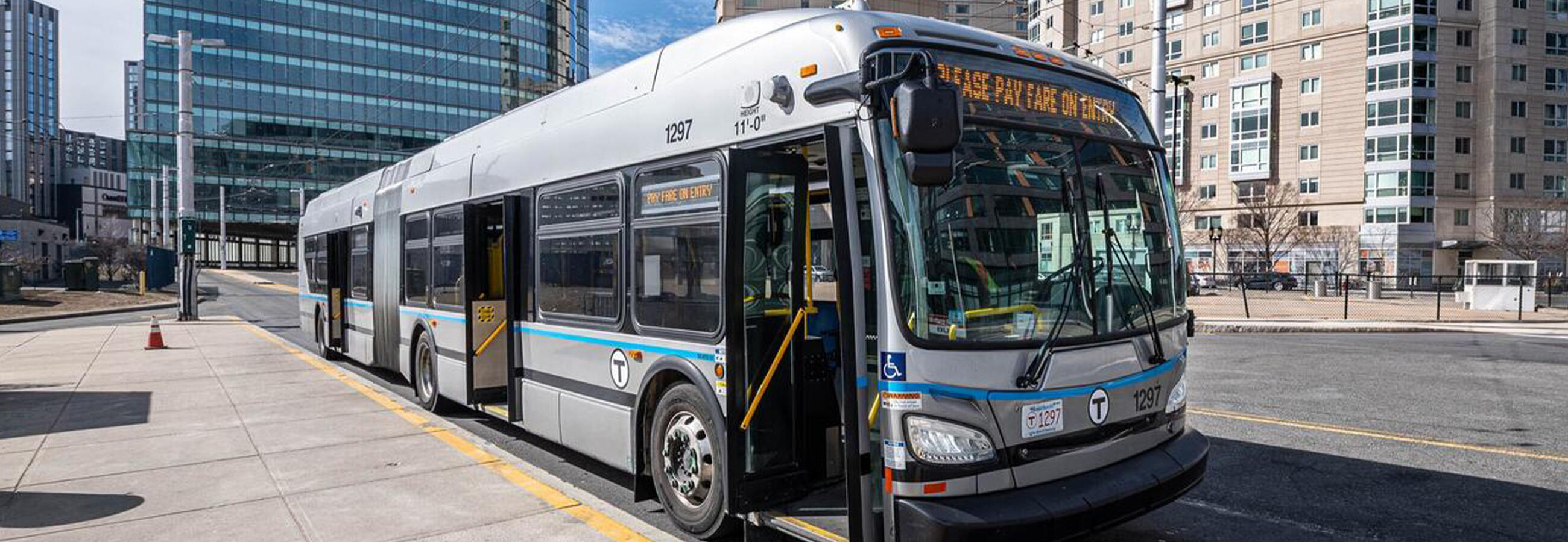 Silver bus parked at a curb