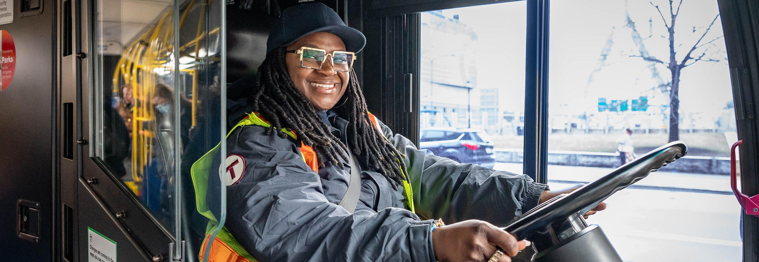 Bus driver smiling behind the wheel of a bus